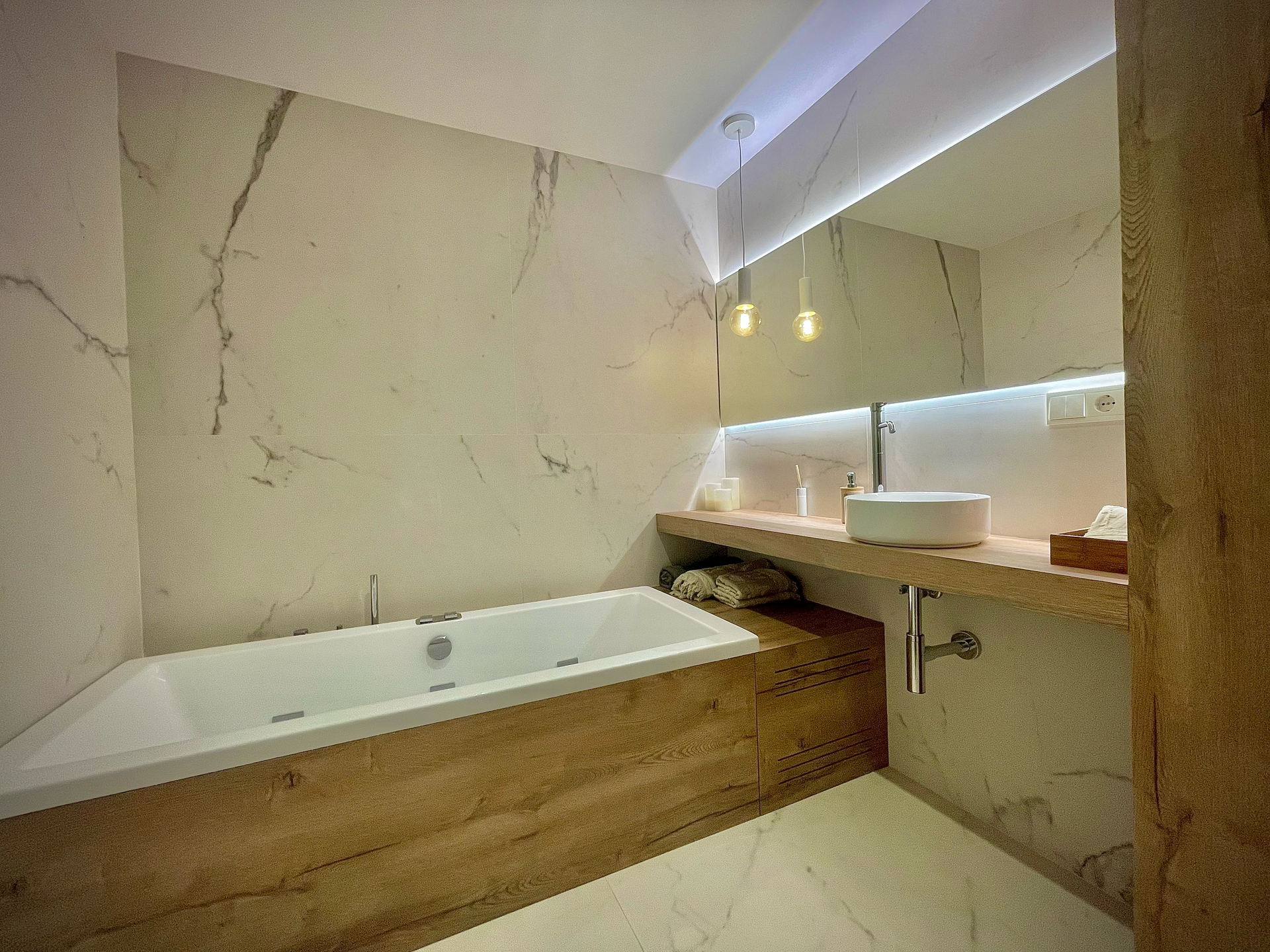 Un baño con bañera, lavabo y espejo.