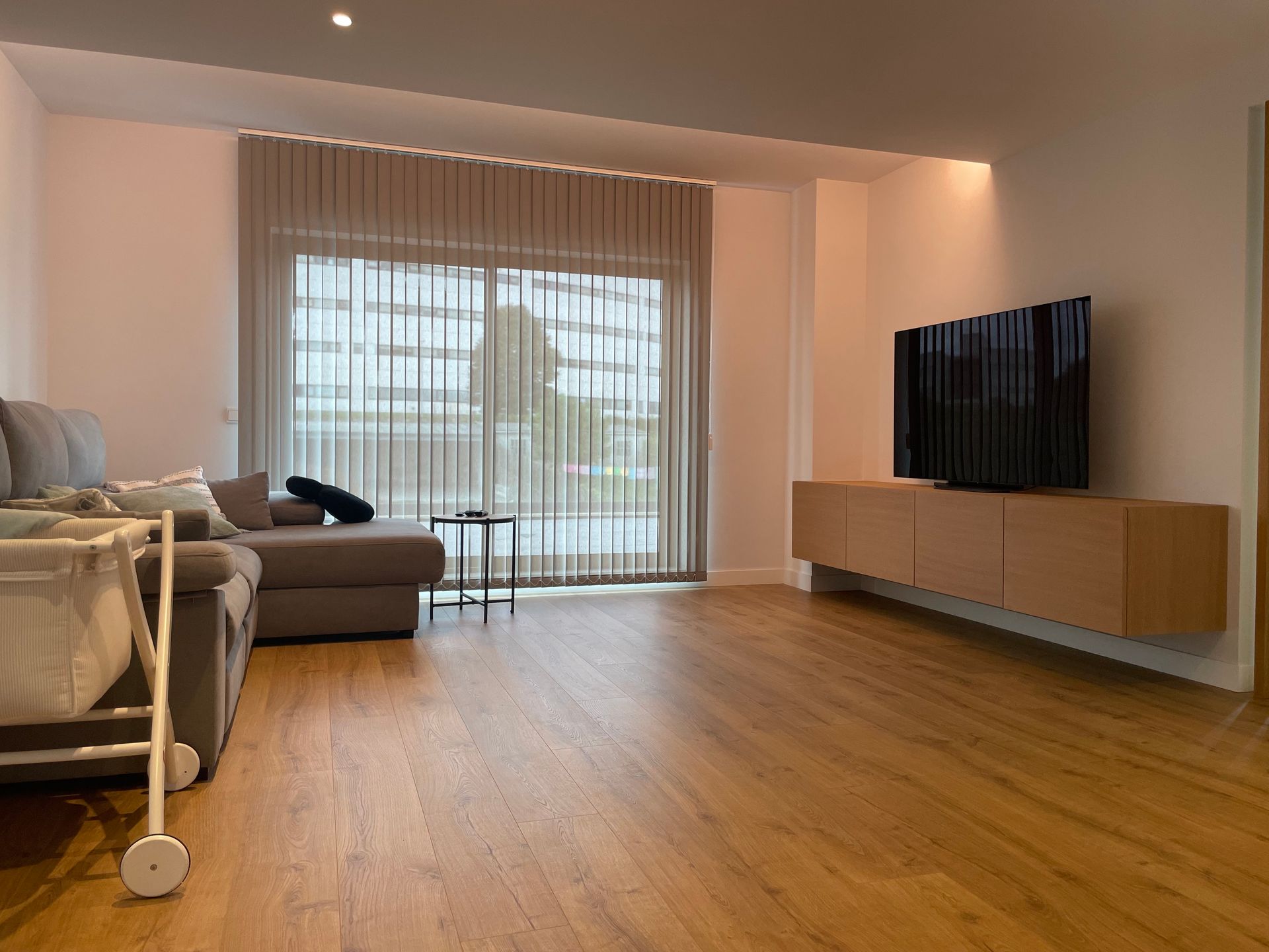 Una sala de estar con un sofá, televisión y una cuna.