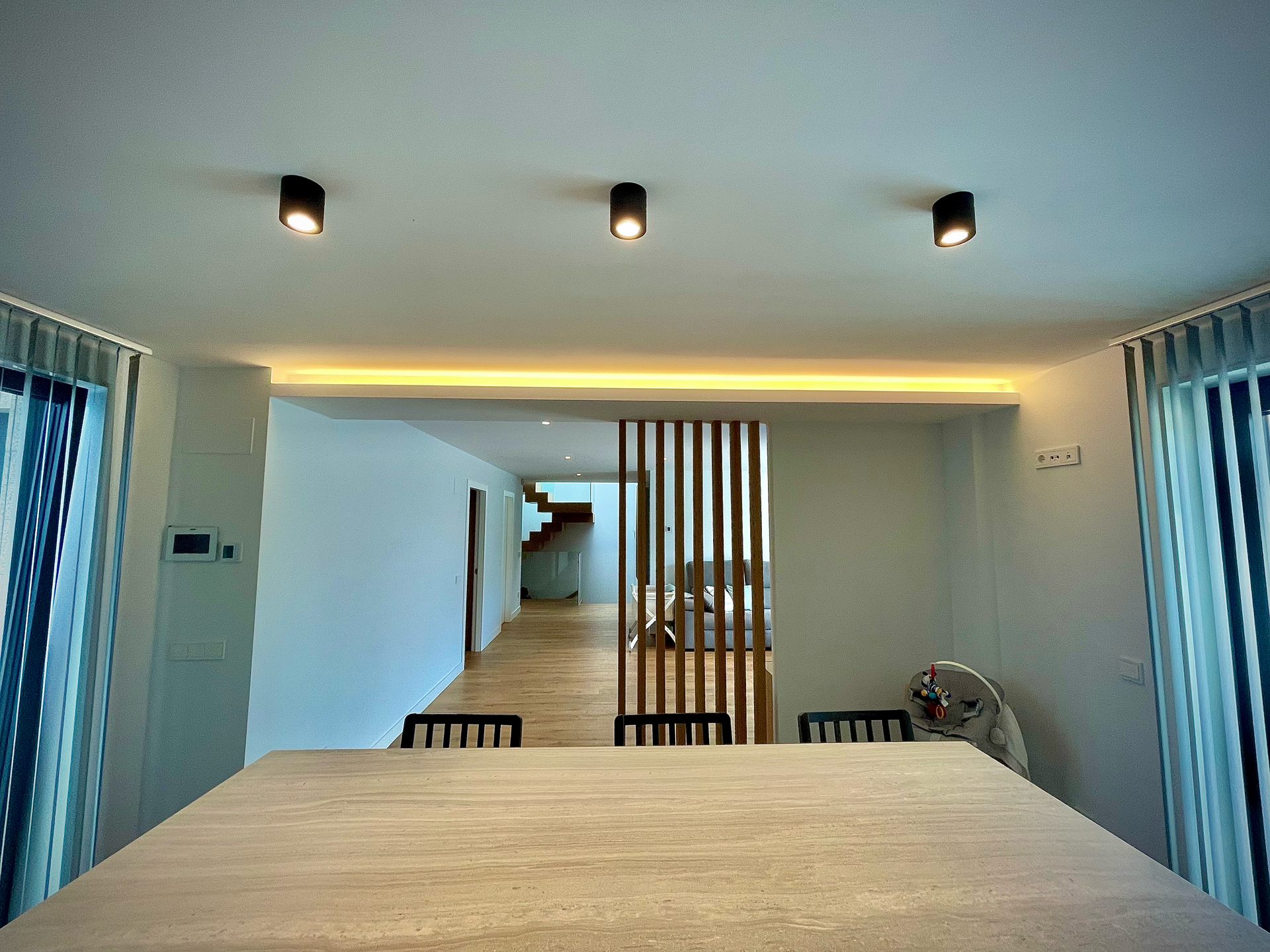 Un comedor con una mesa y sillas y una escalera al fondo.