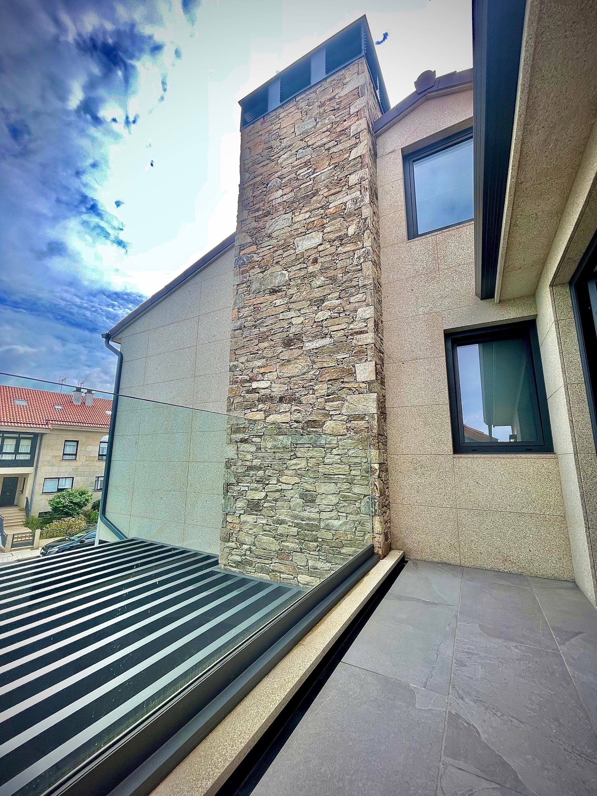 Una casa con una chimenea de piedra en el costado.