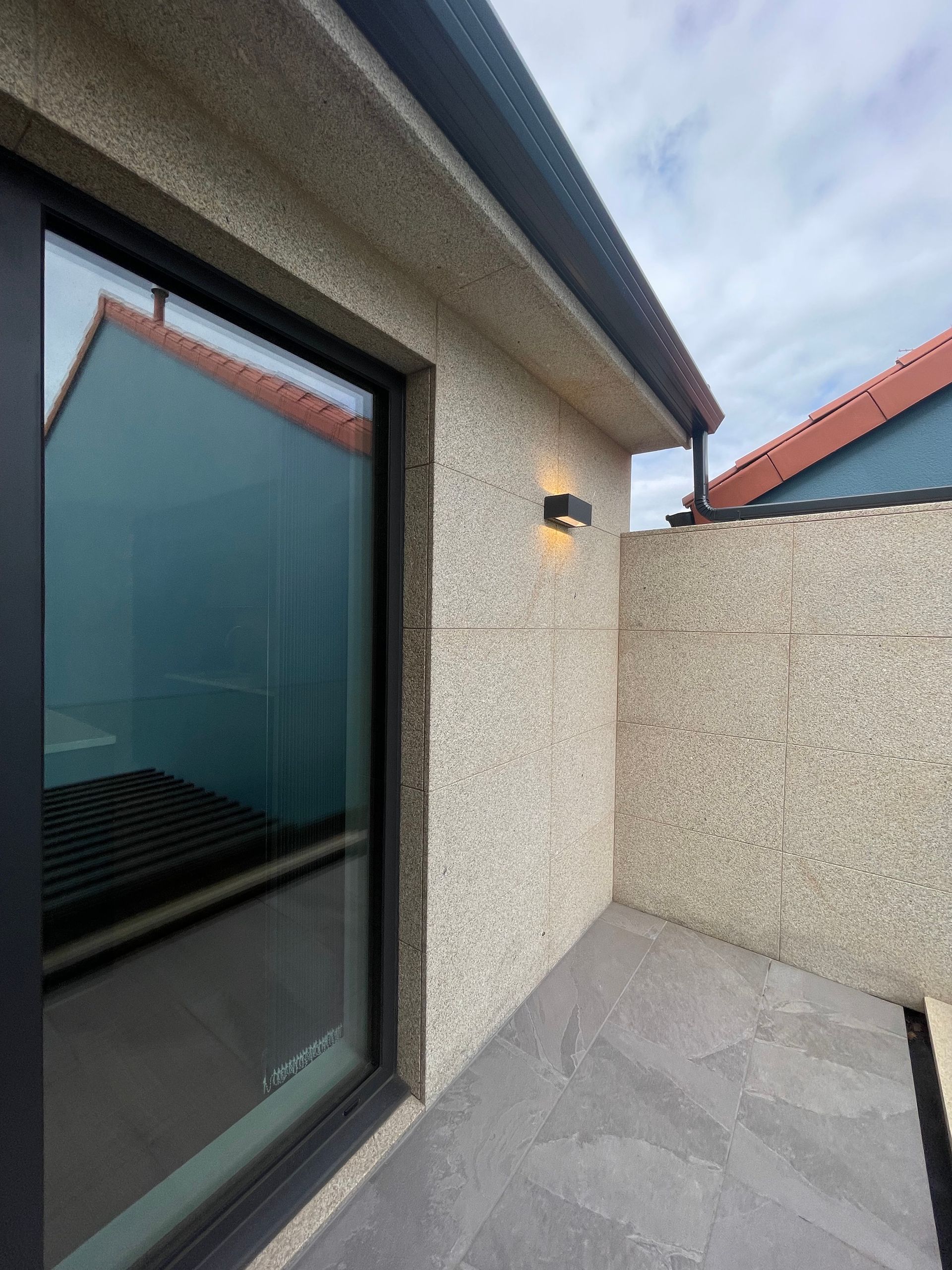 Una casa con una puerta corrediza de vidrio y un reflejo de un edificio en la ventana.