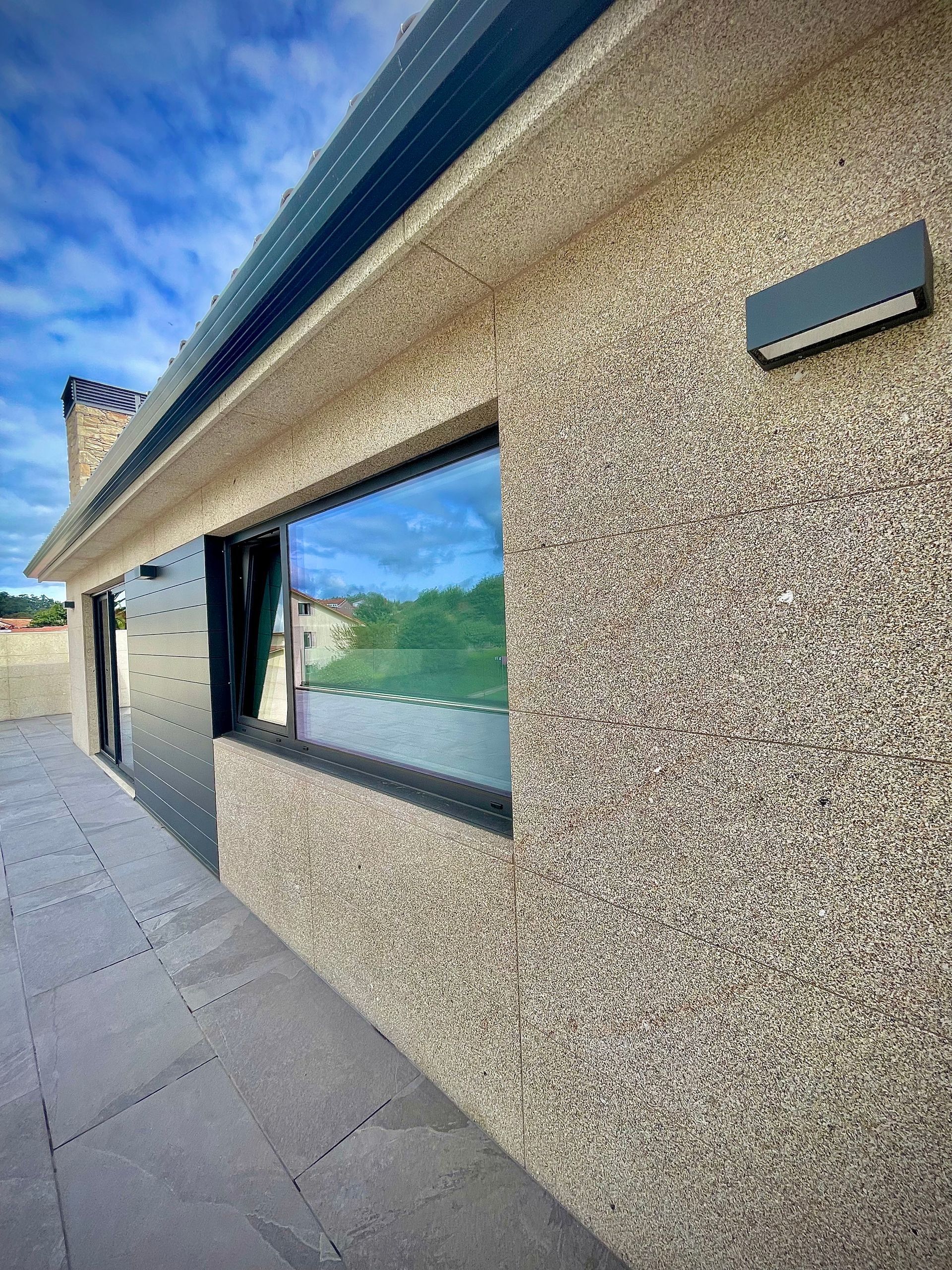 Una casa con una gran ventana en el costado.