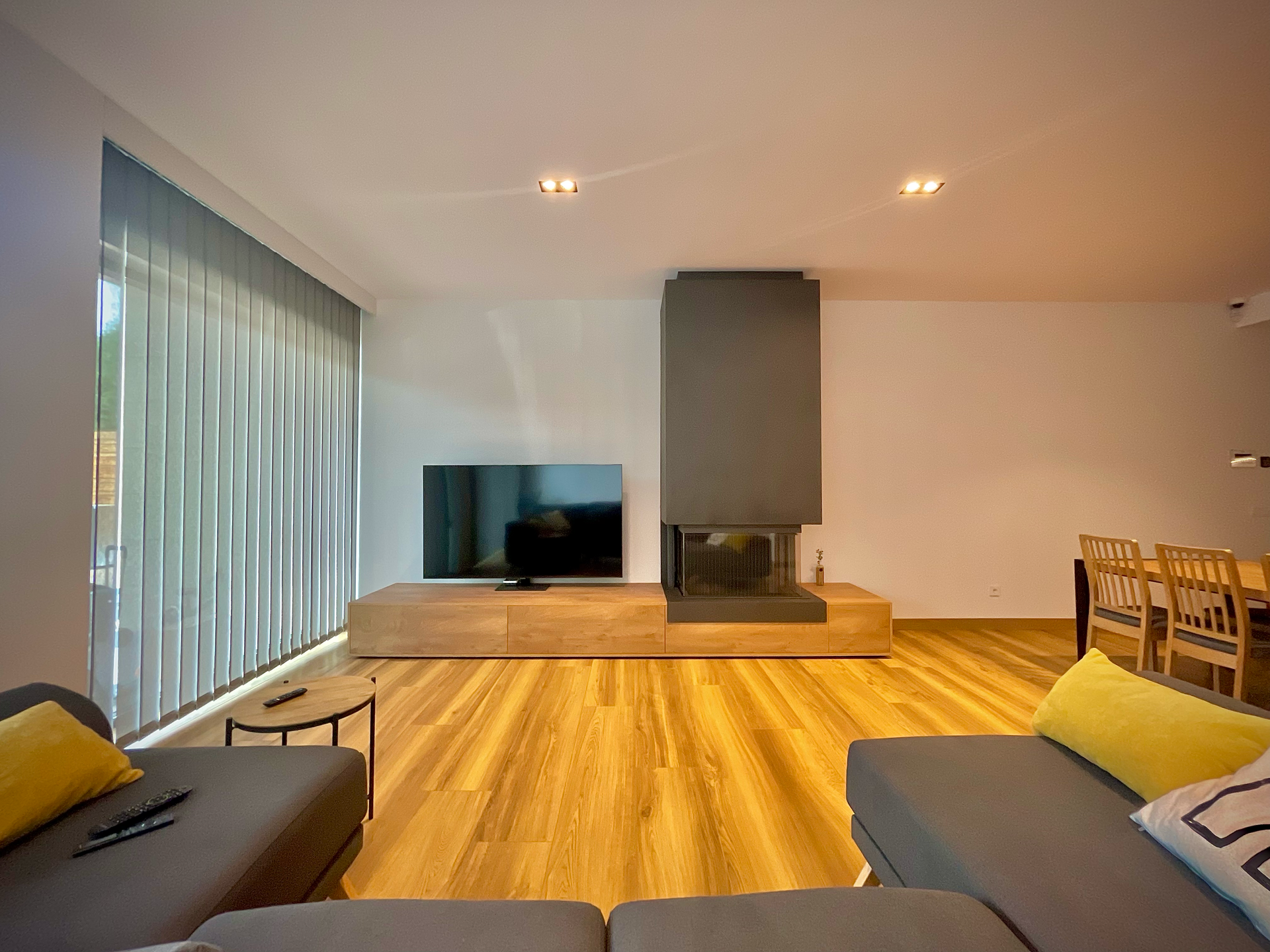 Una sala de estar con sofá, televisión y chimenea.