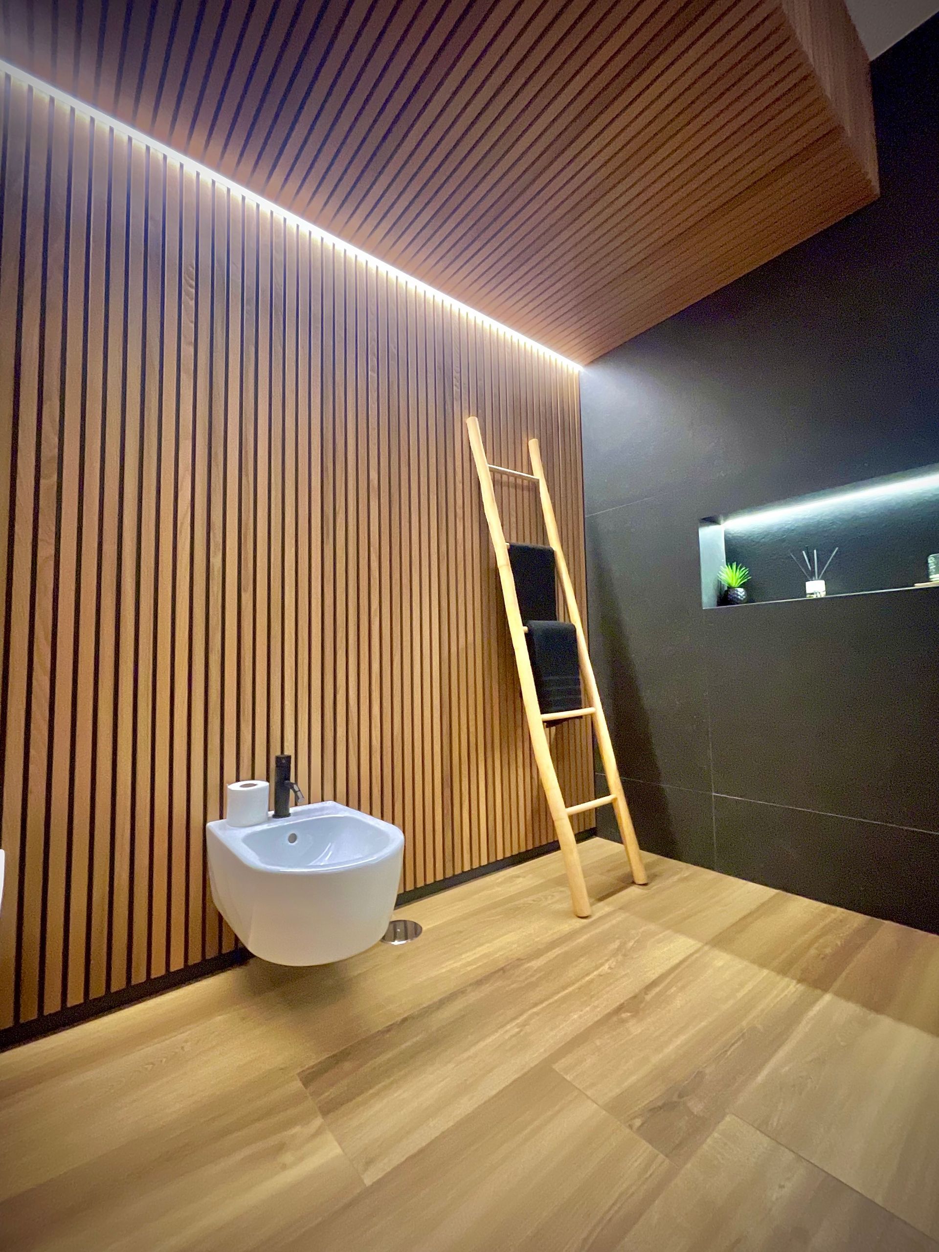 Un baño con bidet, lavabo y escalera.