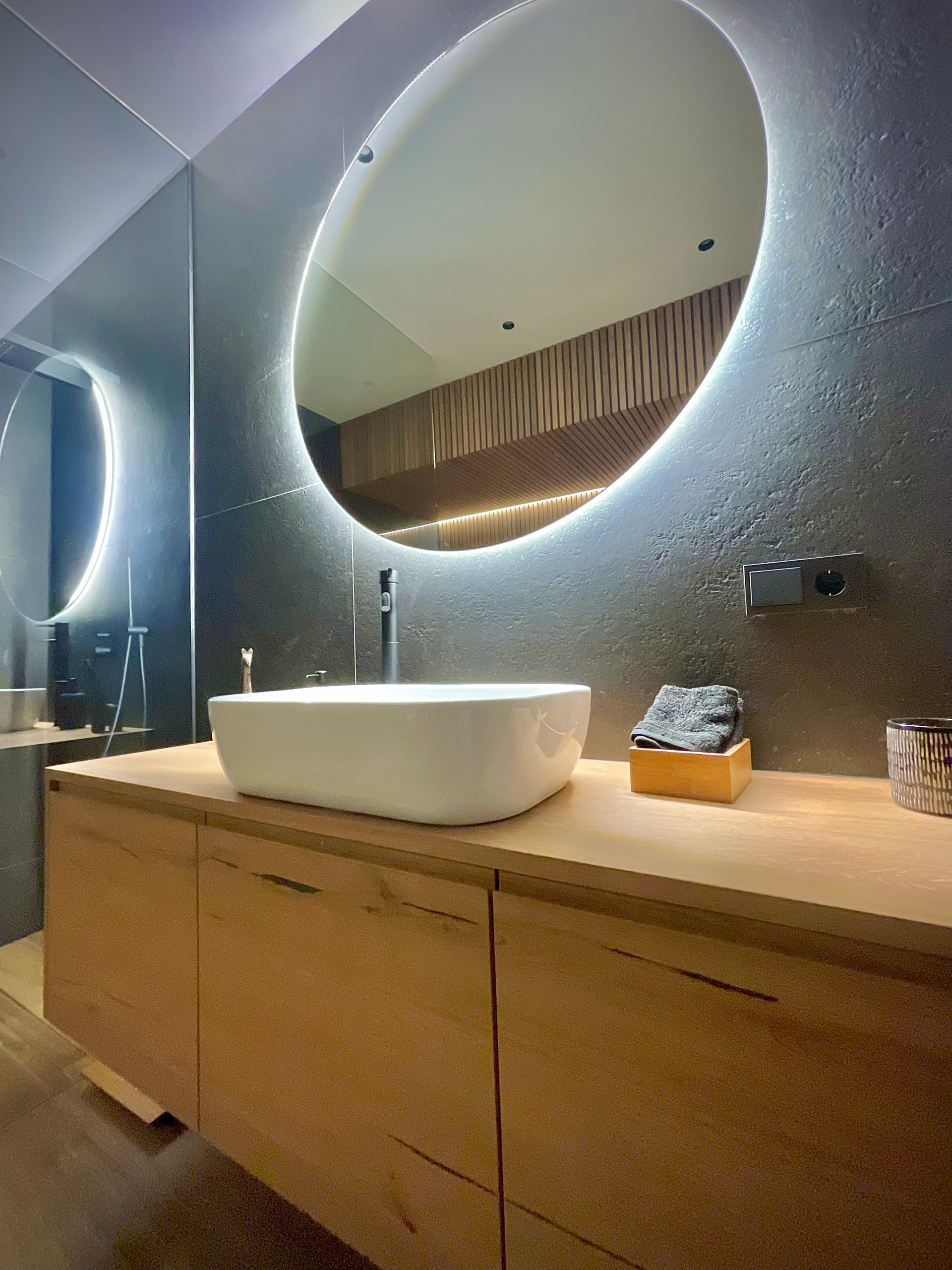 Un baño con dos espejos redondos y un lavabo.