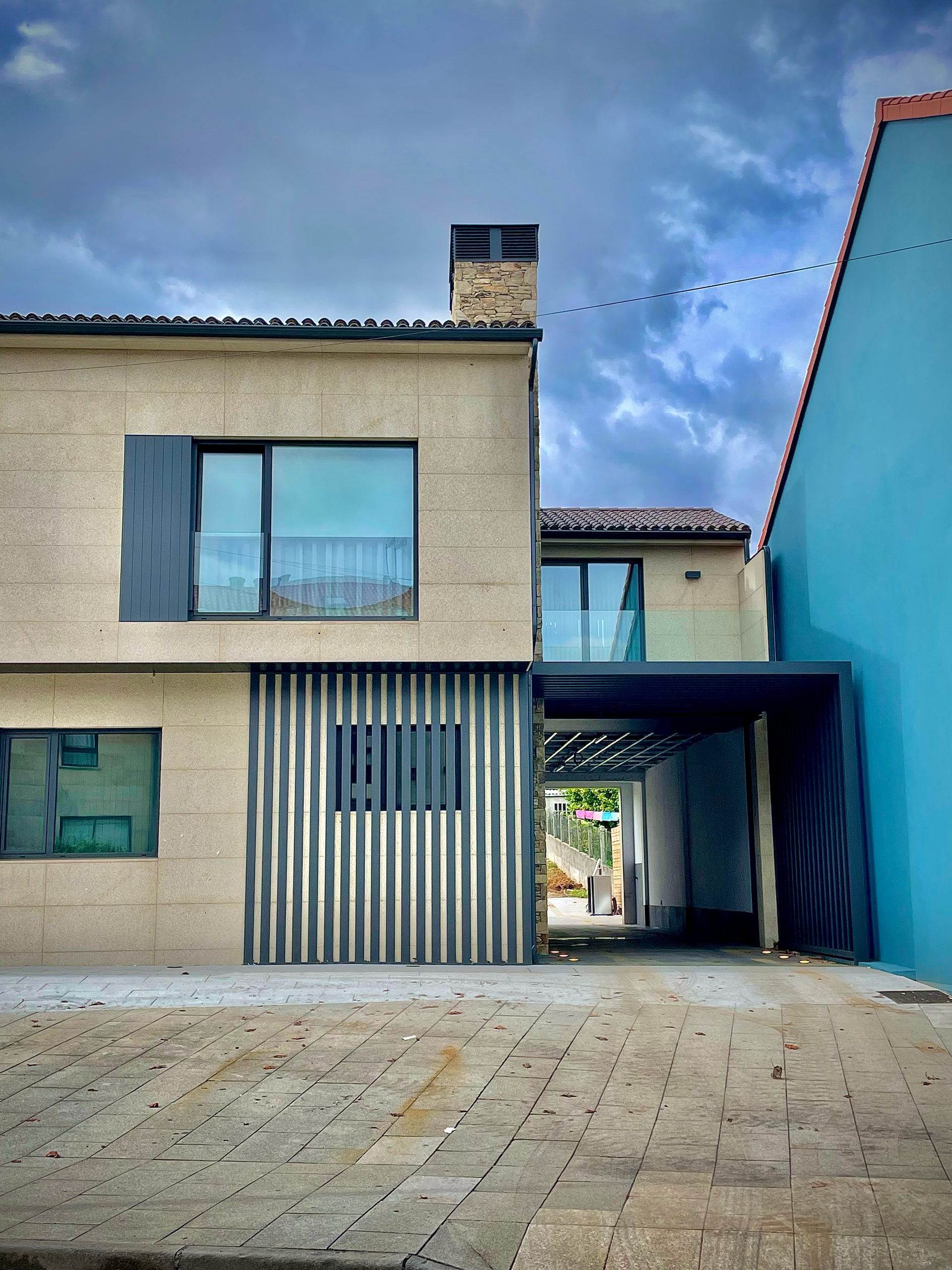 Una casa con una pared azul y una entrada de ladrillo