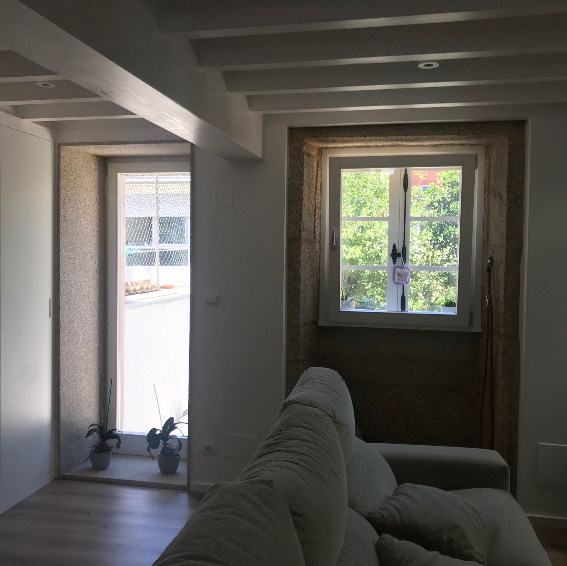 Una sala de estar con un sofá y una ventana.