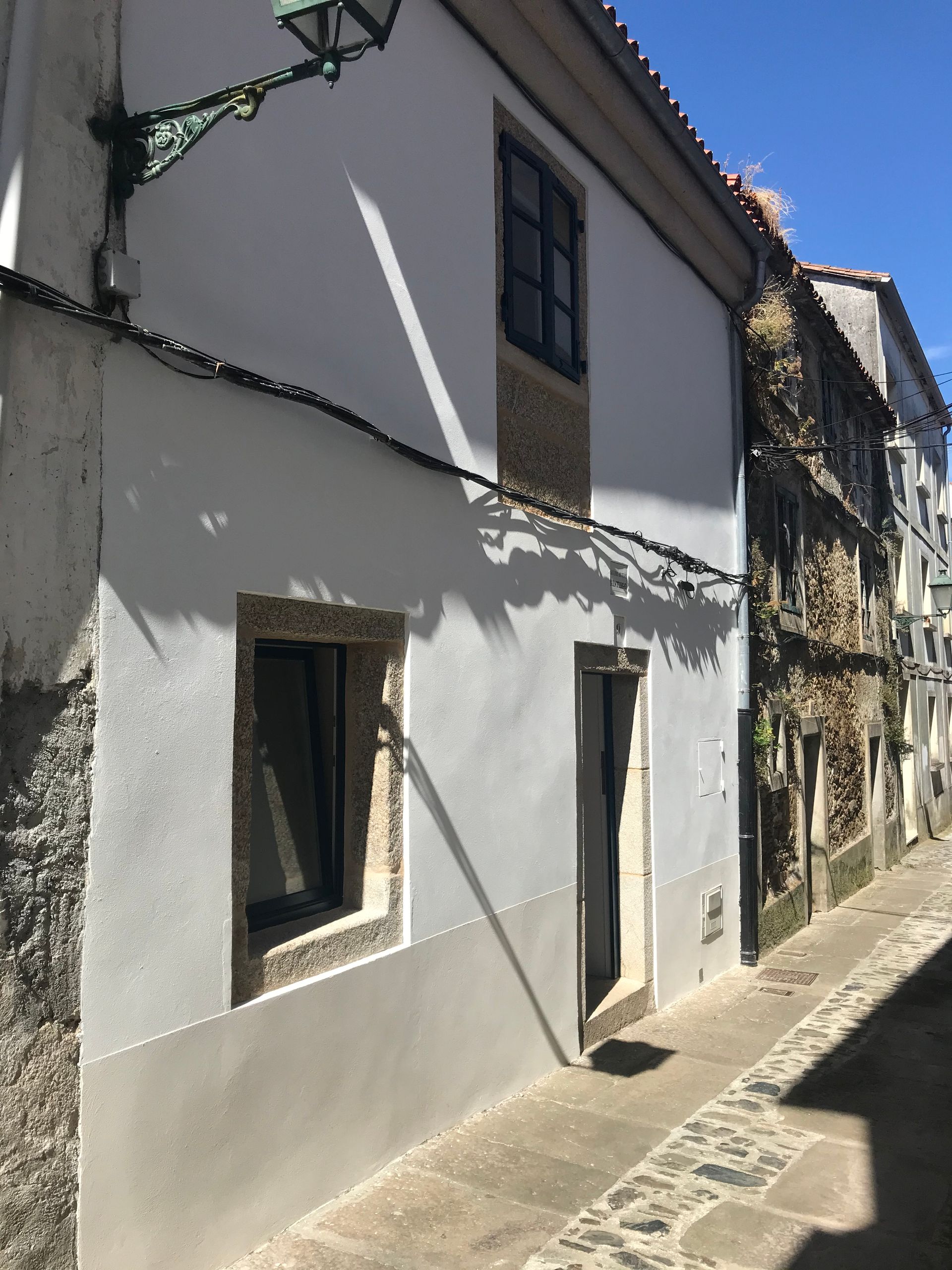 Un edificio blanco con una lámpara al costado.