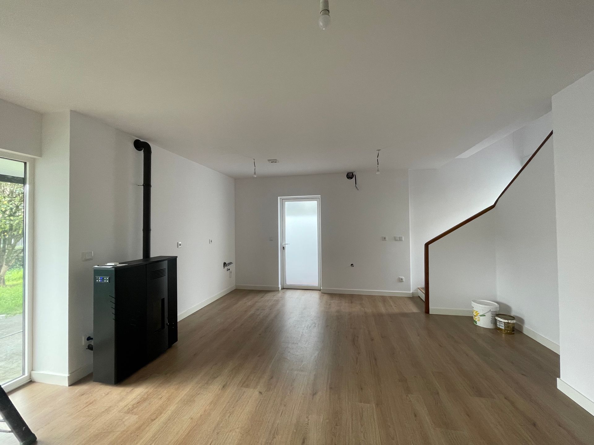 Una sala de estar con pisos de madera y paredes blancas.