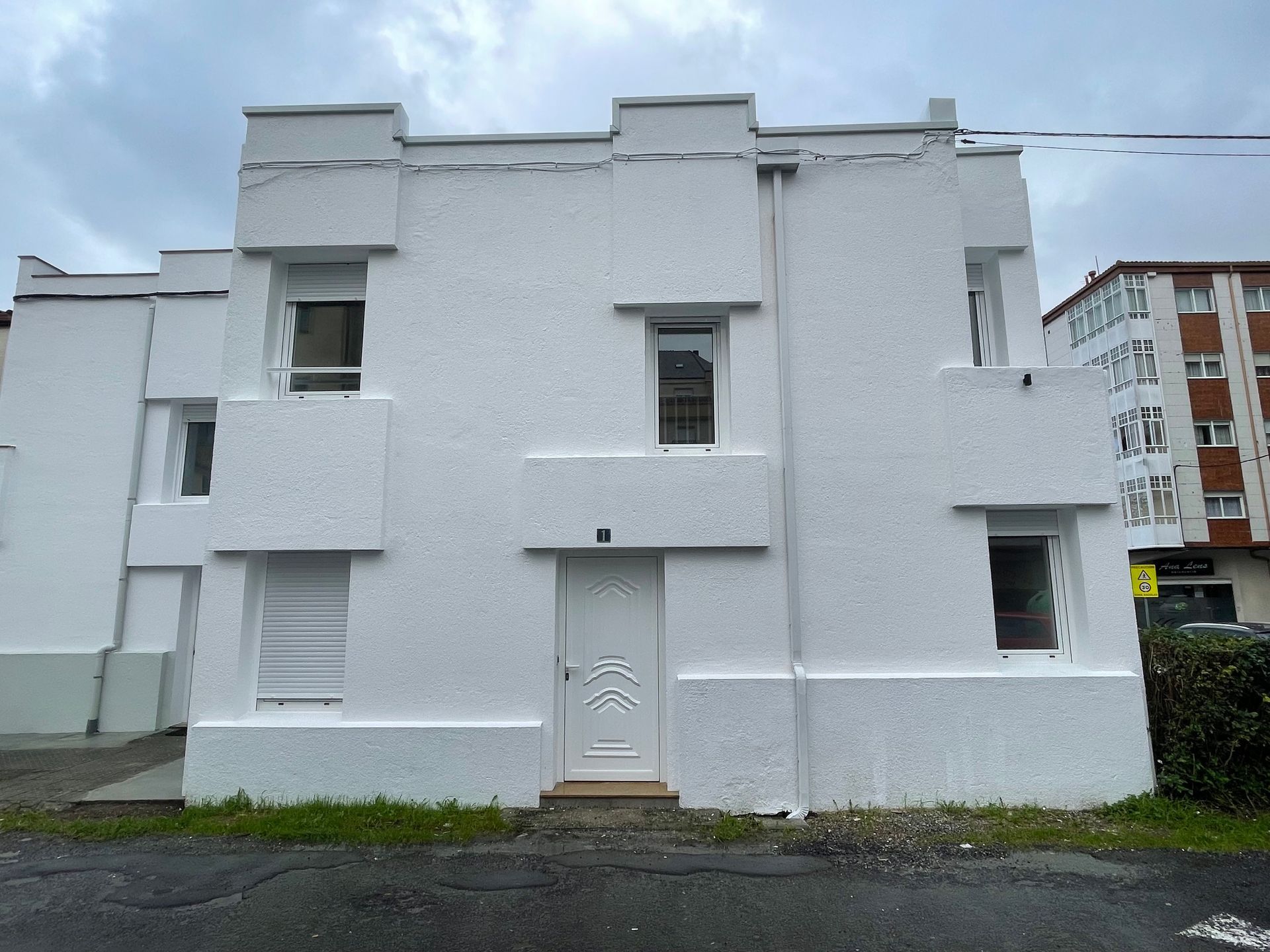 Un edificio blanco con una puerta y ventanas blancas