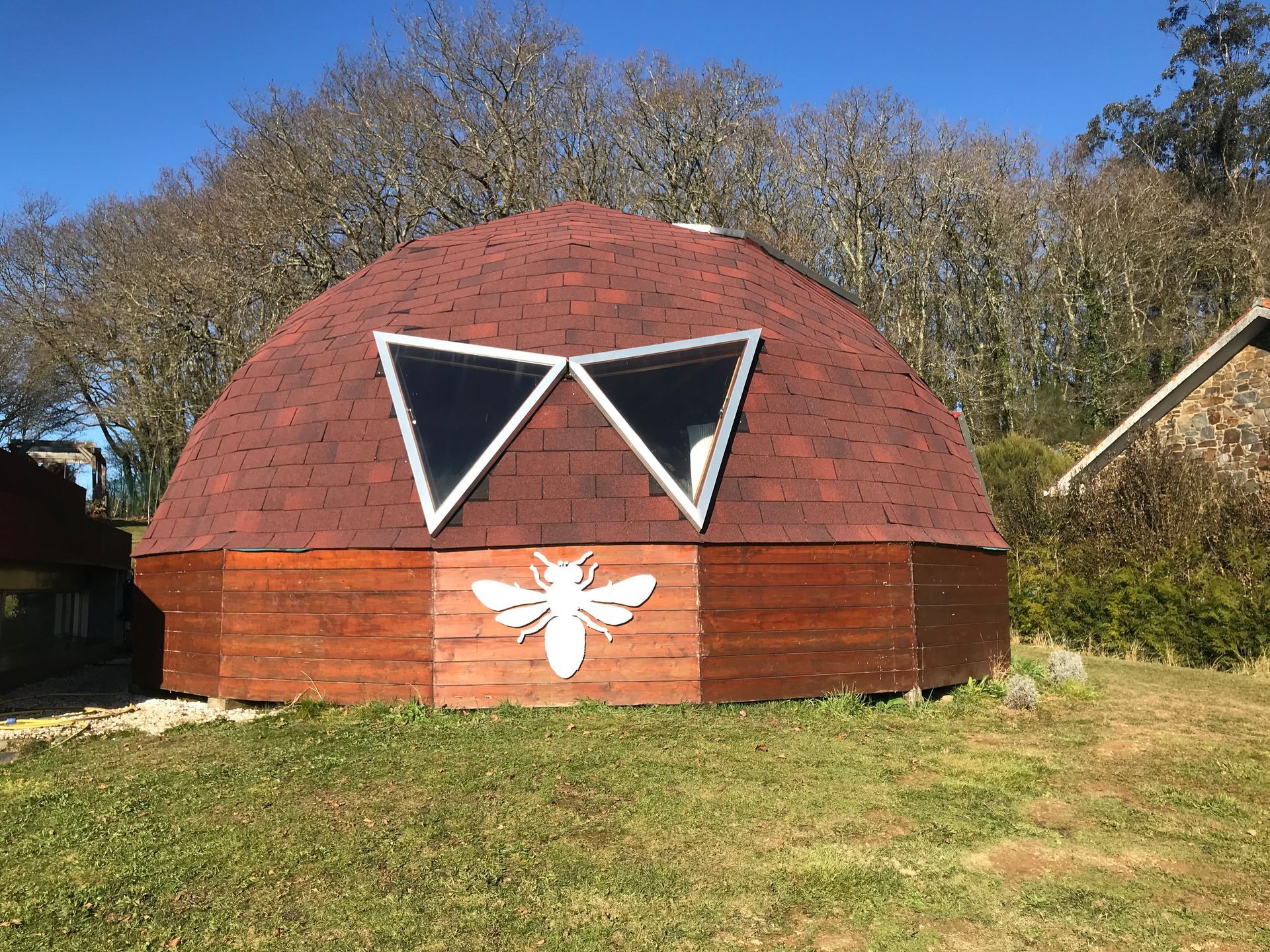 Un edificio en forma de cúpula con una abeja pintada en el costado.