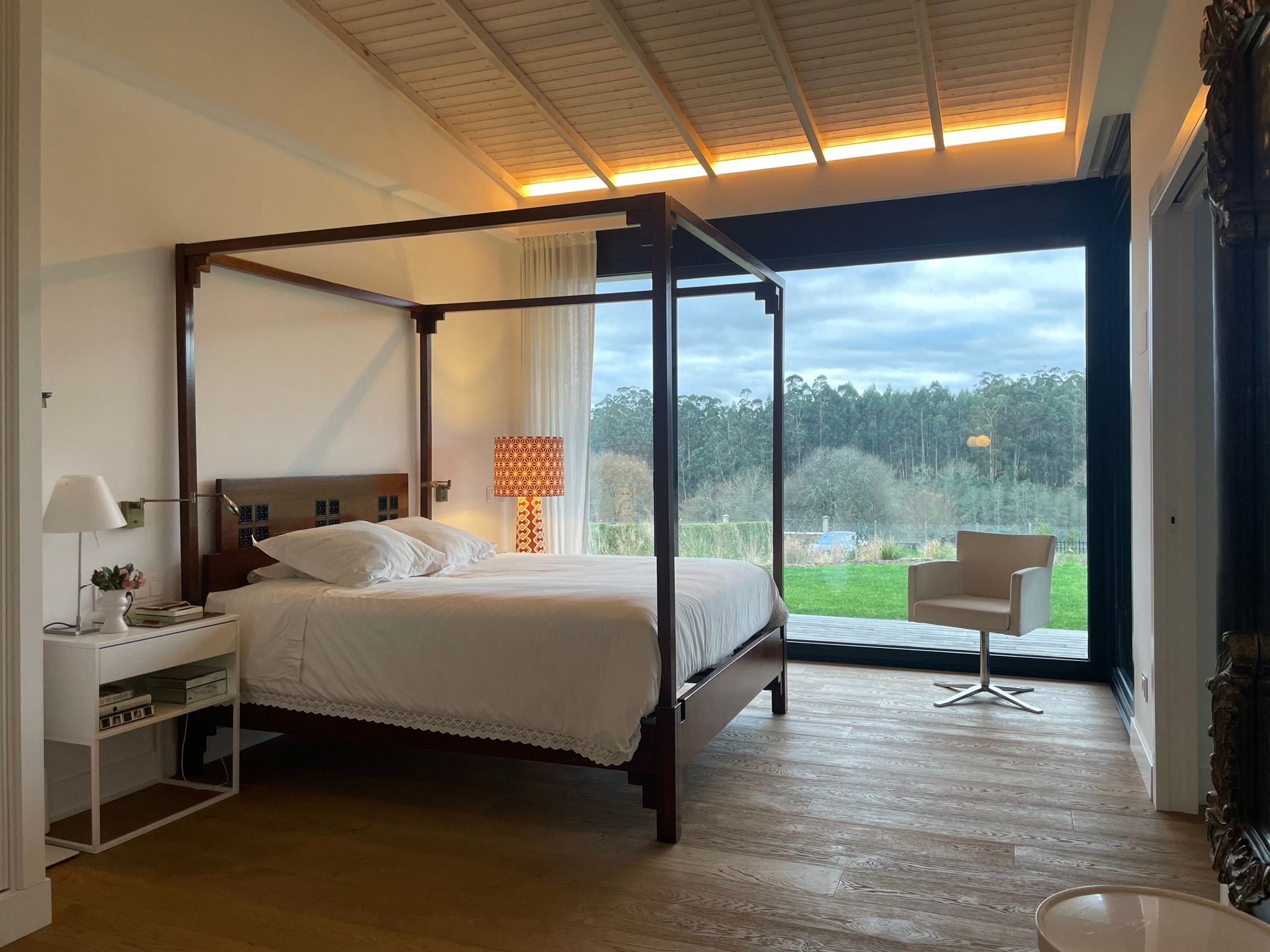 Un dormitorio con una cama con dosel y una gran ventana.