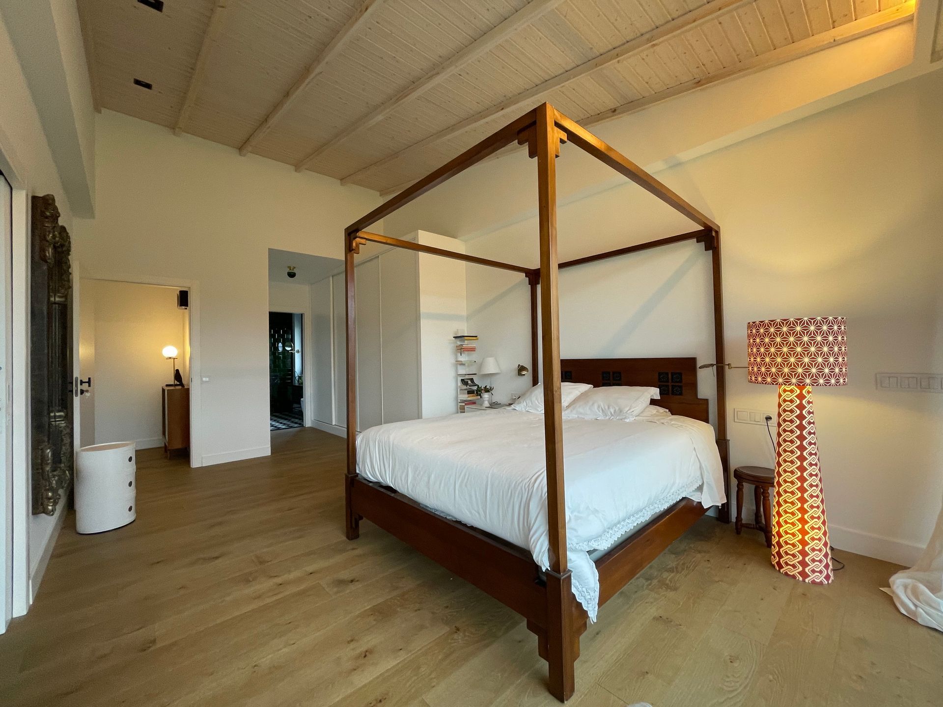 Un dormitorio con una cama con dosel y una lámpara.