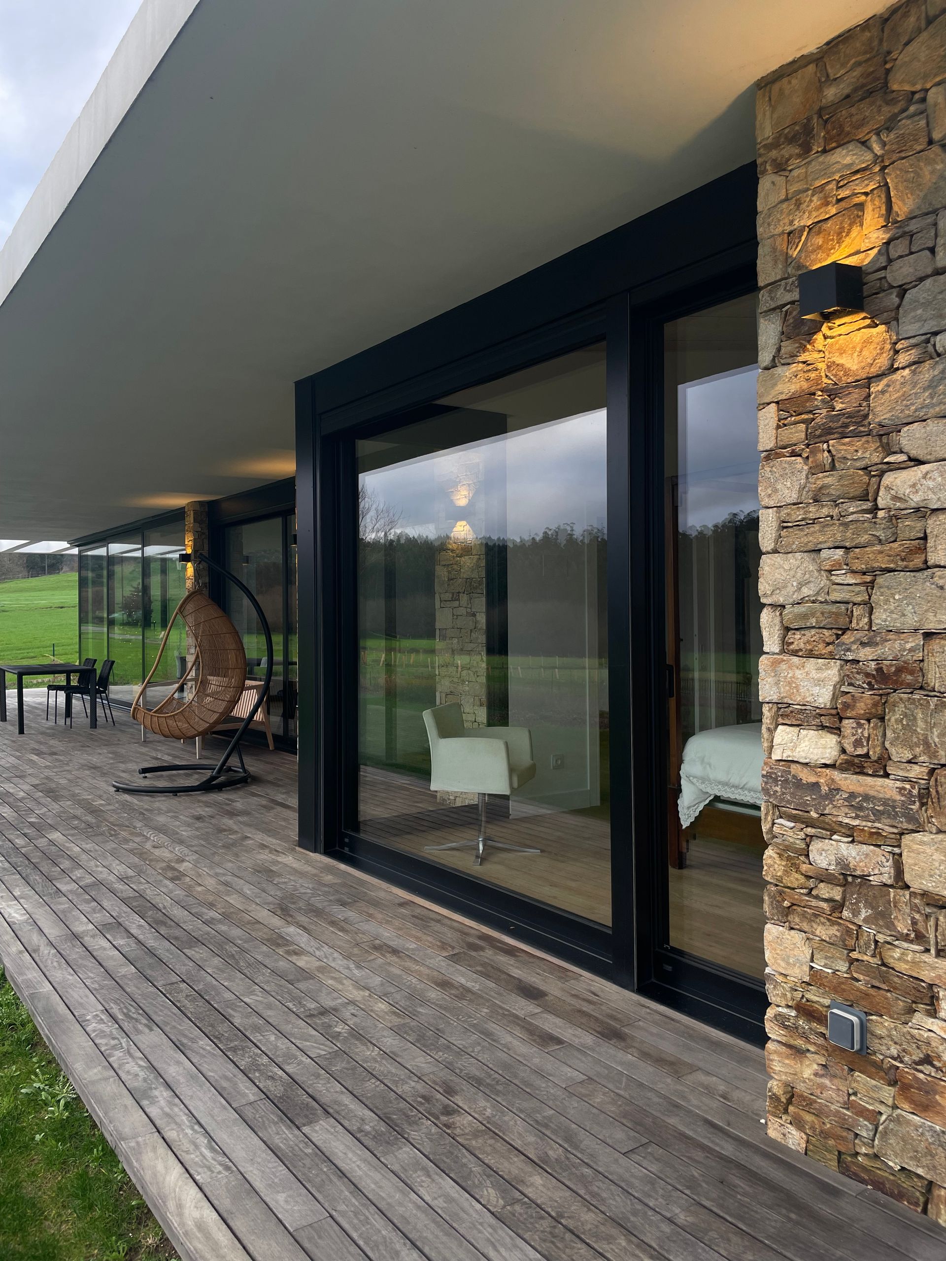 Una casa con terraza de madera y puertas corredizas de vidrio.
