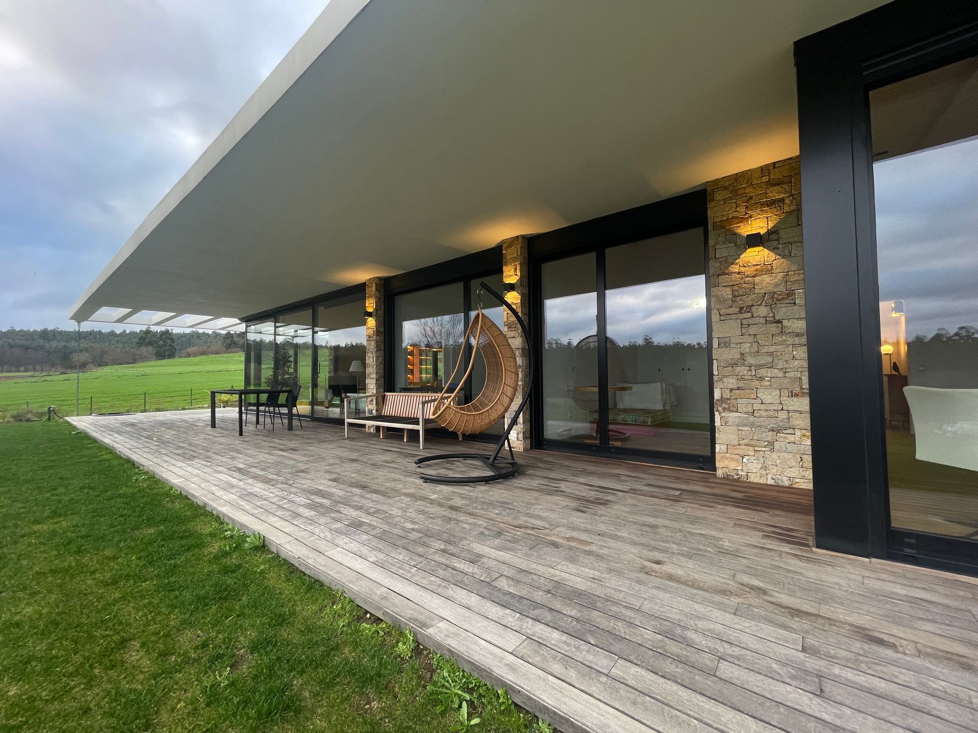 Una casa grande con una terraza de madera en el frente.
