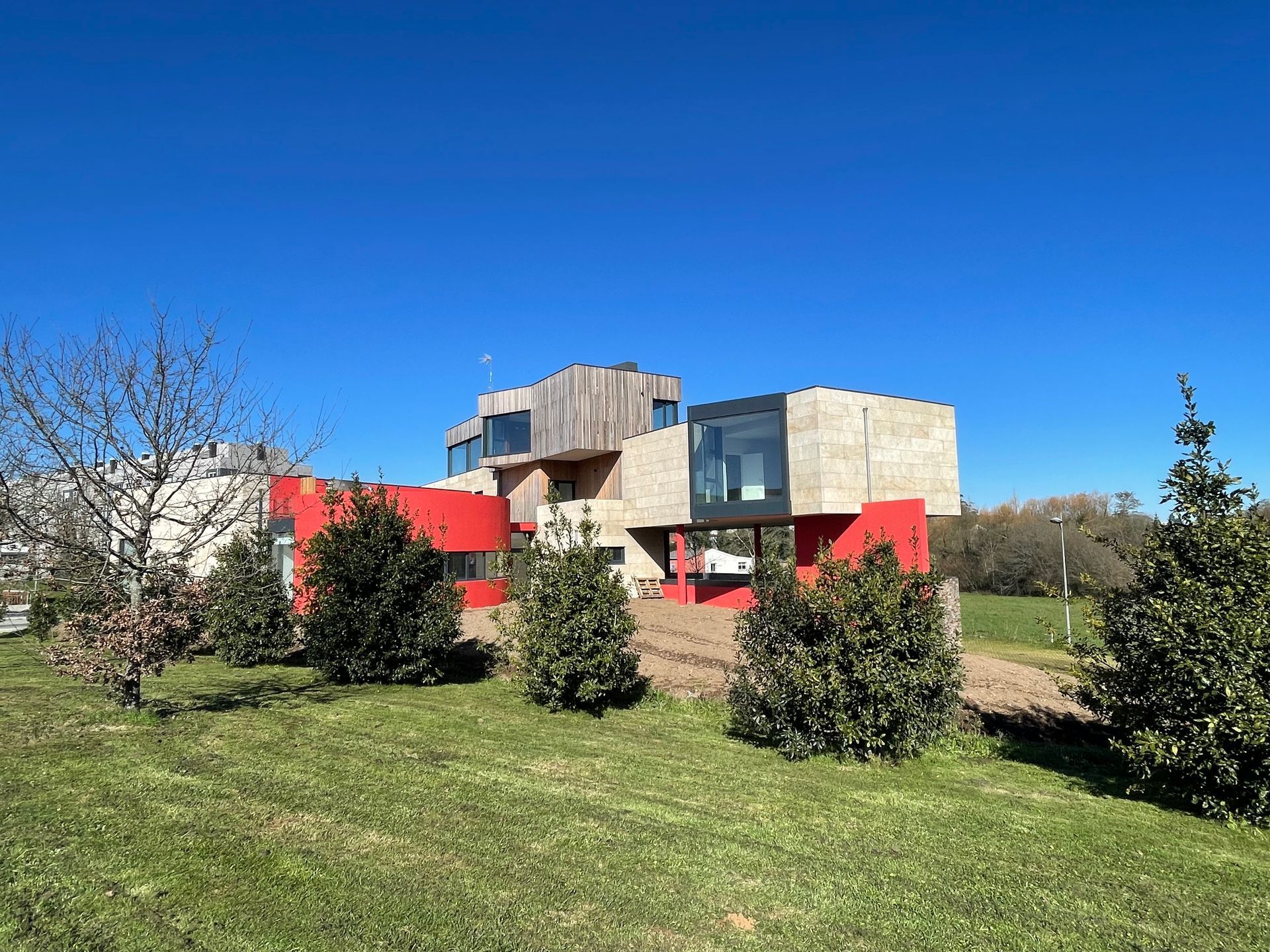 Una gran casa roja está situada en el medio de un campo de hierba.
