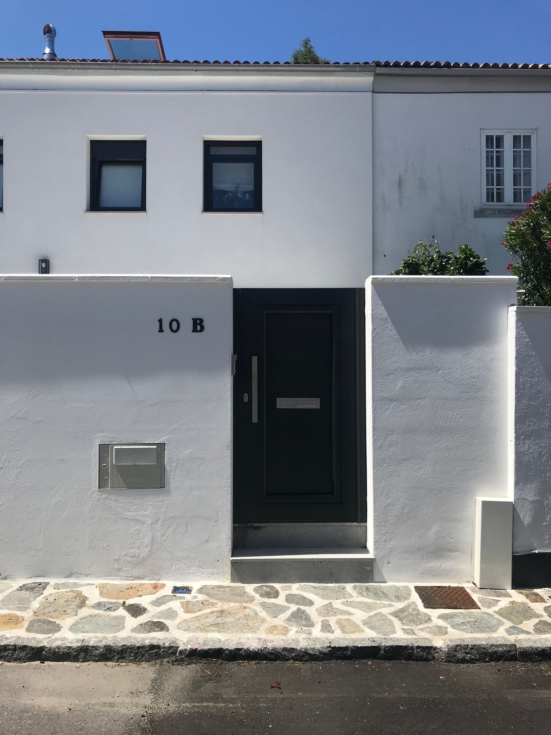 Una casa blanca con el número 10b en el frente
