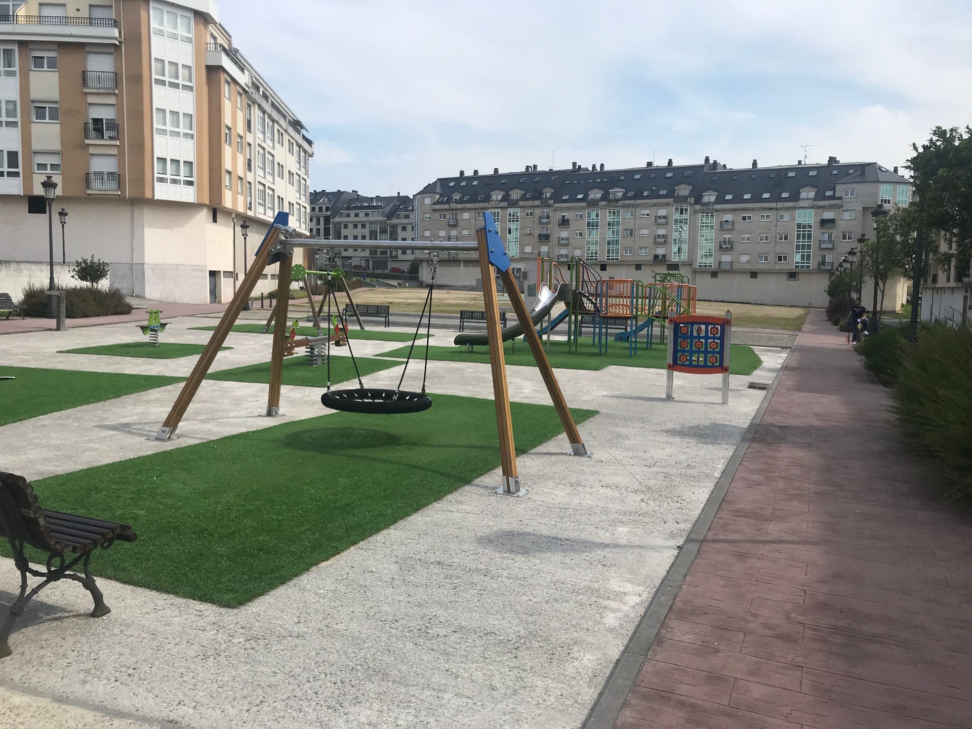 Un parque infantil con un columpio de neumático en el medio.
