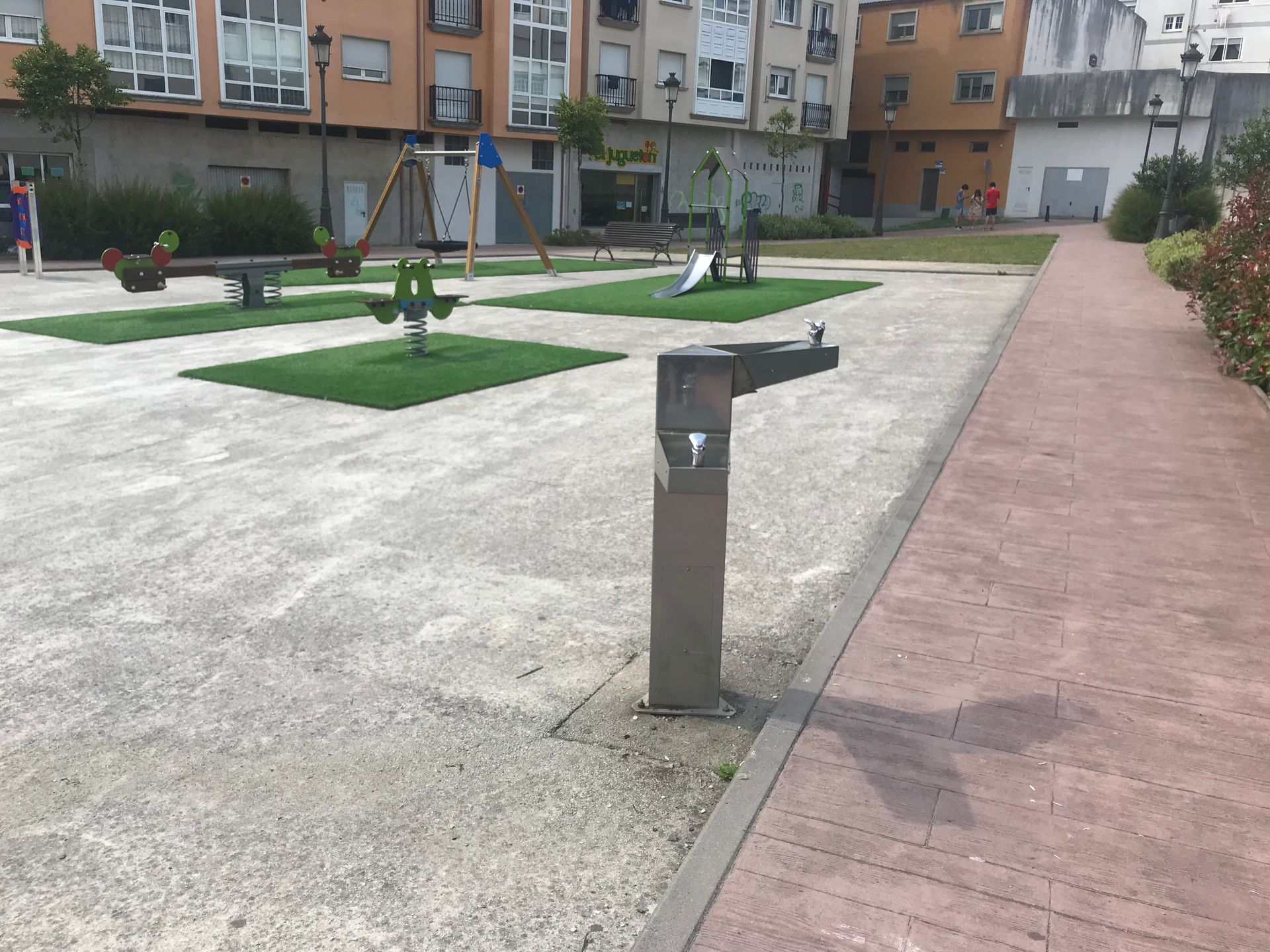 Un parque con un columpio y una fuente de agua