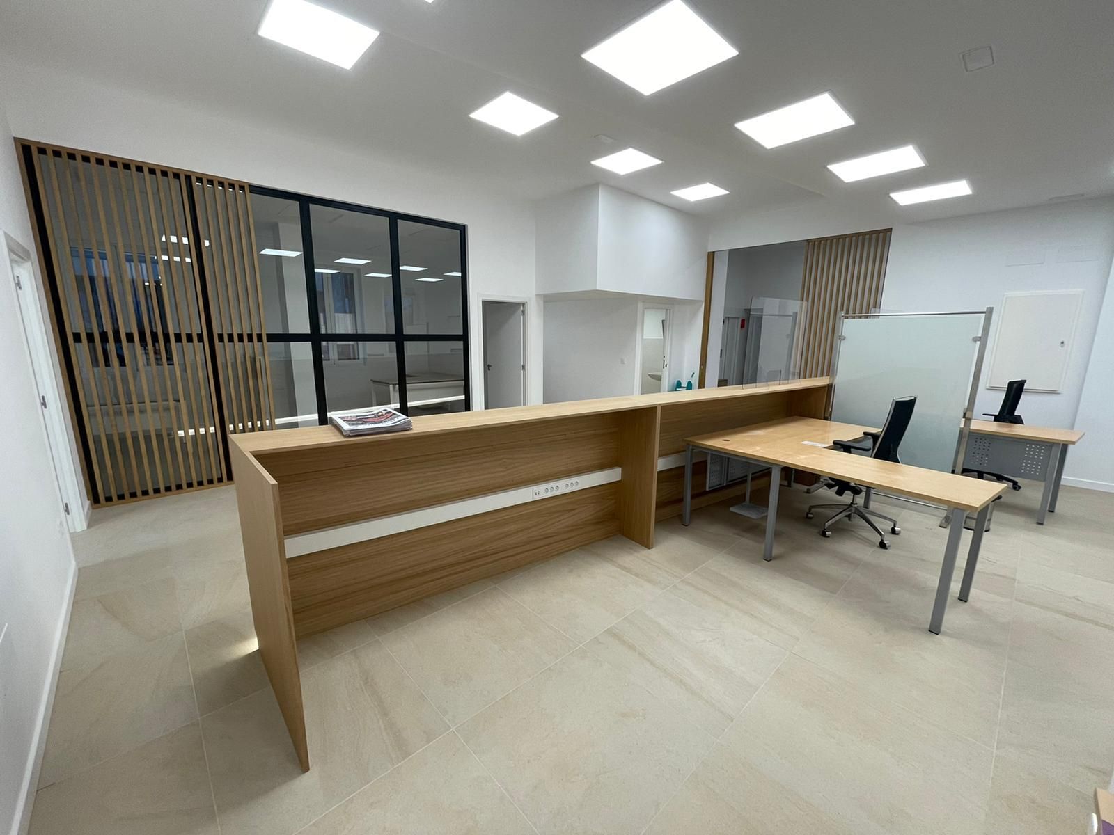 Una habitación con un escritorio de madera y una computadora encima.