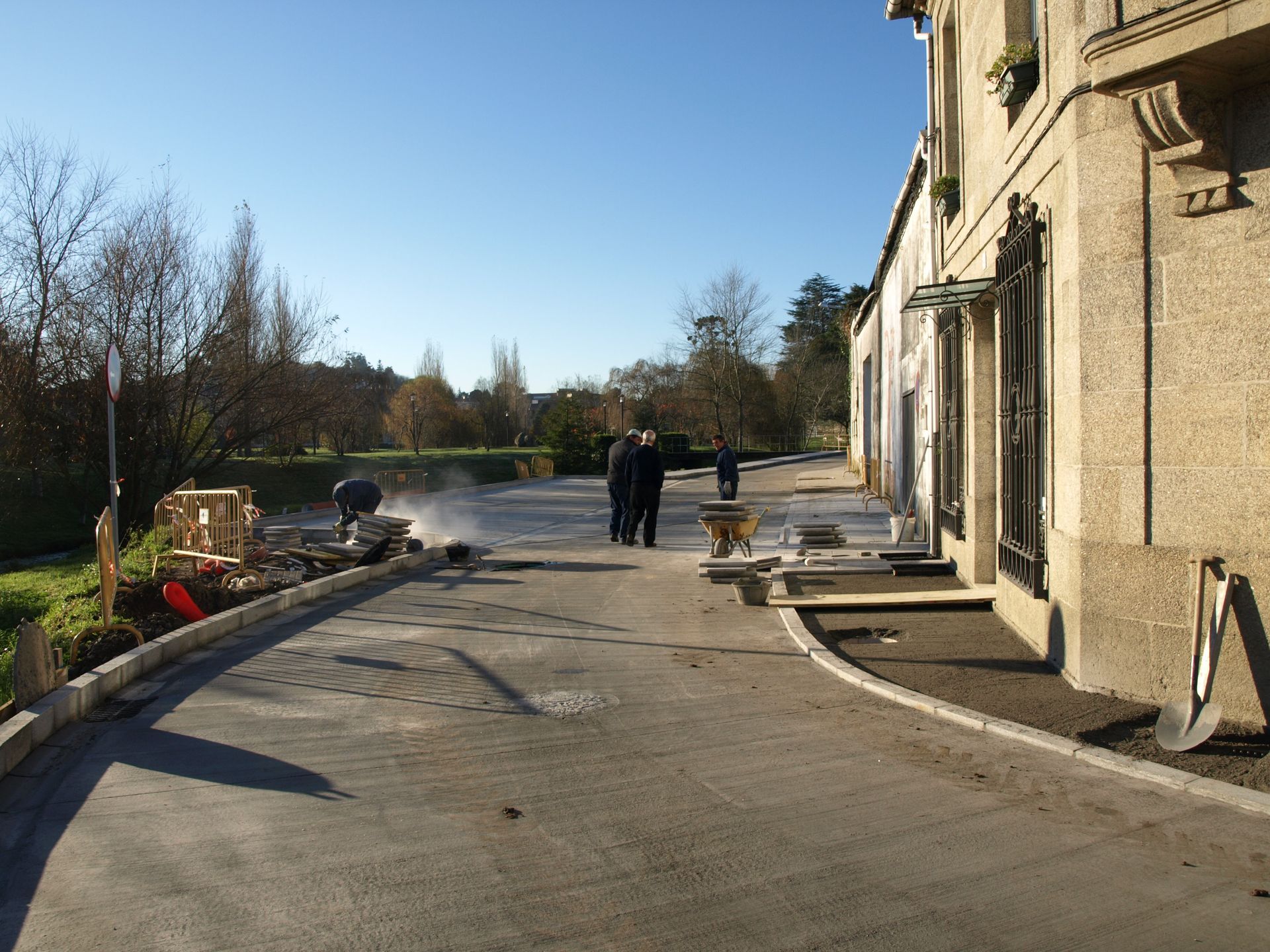 Un grupo de personas camina por una calle frente a un edificio.