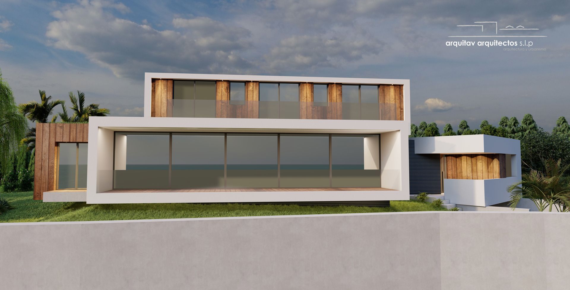 Una casa moderna con muchas ventanas está situada en la cima de una colina.