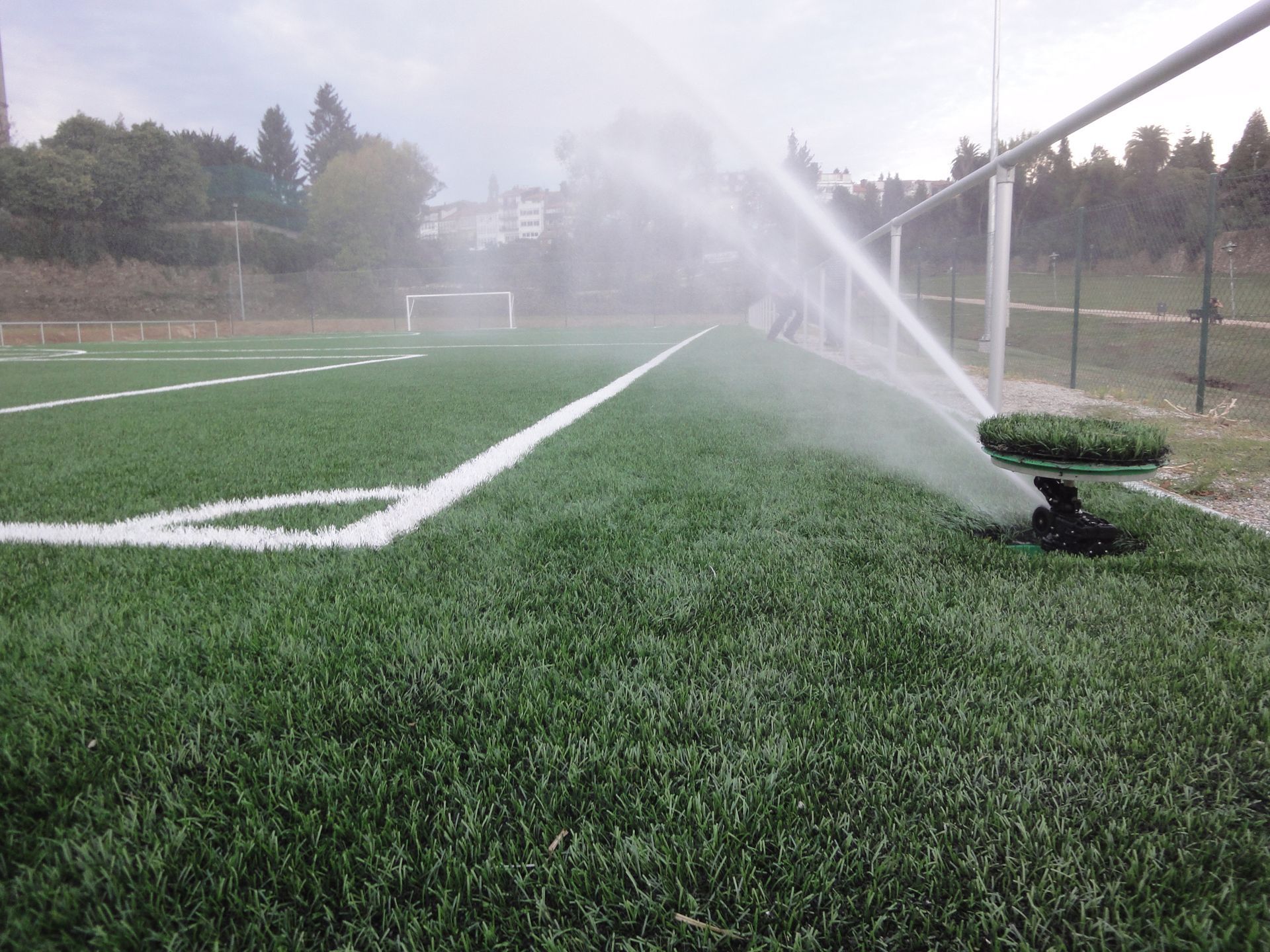 Un aspersor está rociando agua en un campo de fútbol