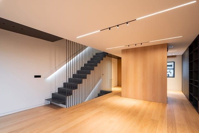 Una habitación vacía con una escalera y un suelo de madera.
