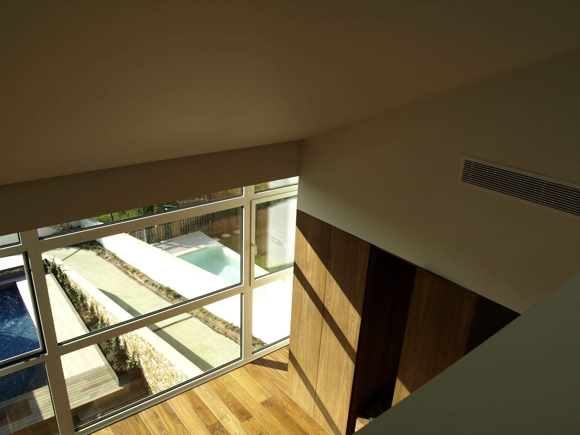 Una habitación con muchas ventanas y una piscina al fondo.