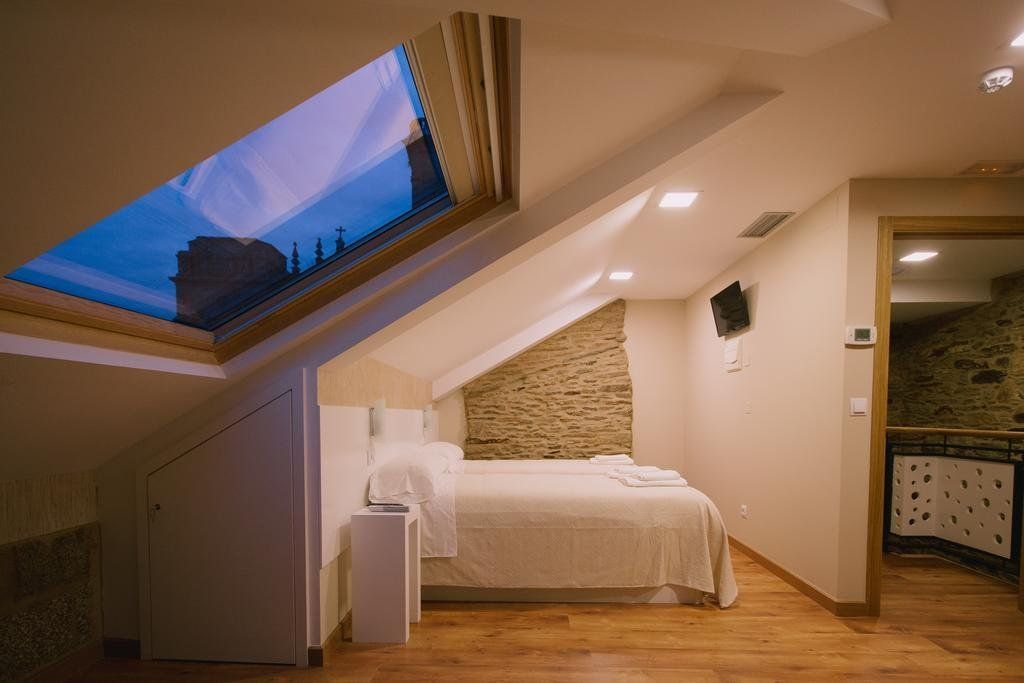 Un dormitorio con una cama y una claraboya en el techo.