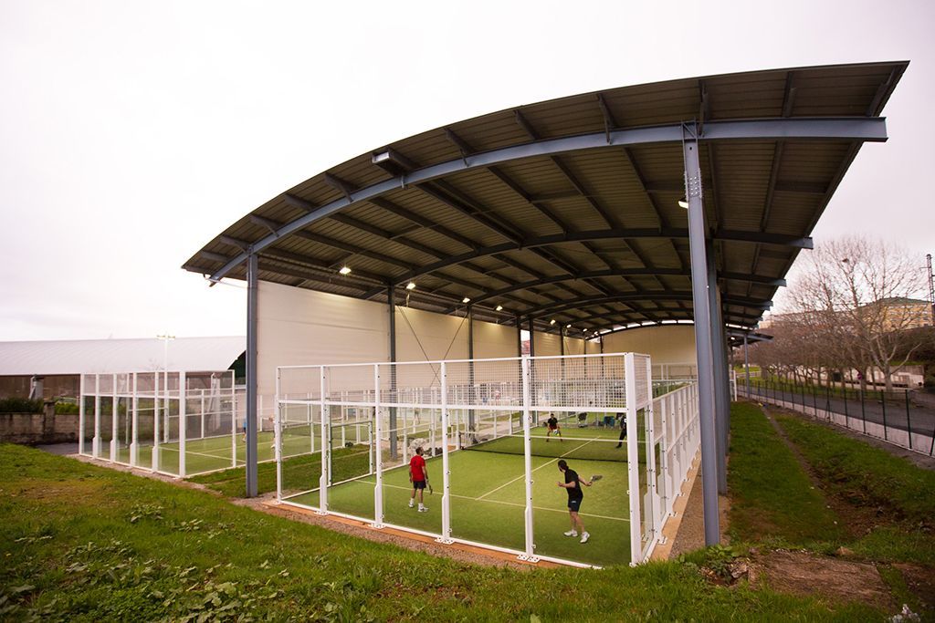 Un grupo de personas está jugando al tenis bajo un dosel.