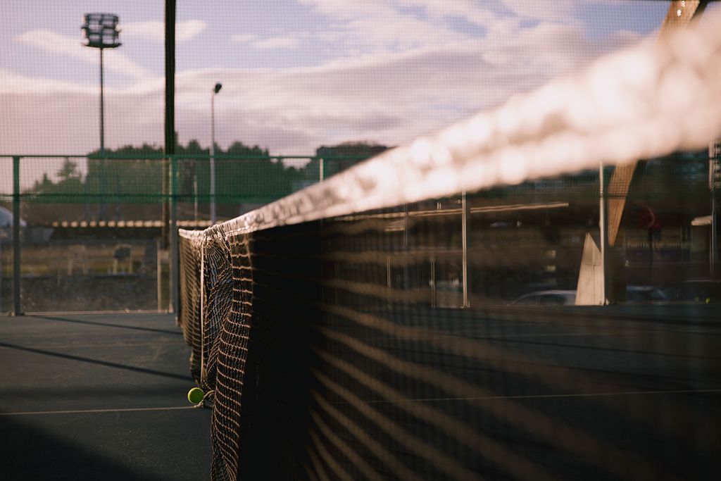 Un primer plano de una red de tenis en una cancha de tenis.