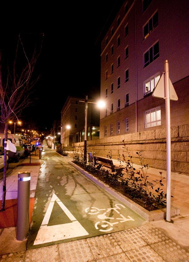 Un carril bici está pintado al costado de la carretera por la noche.