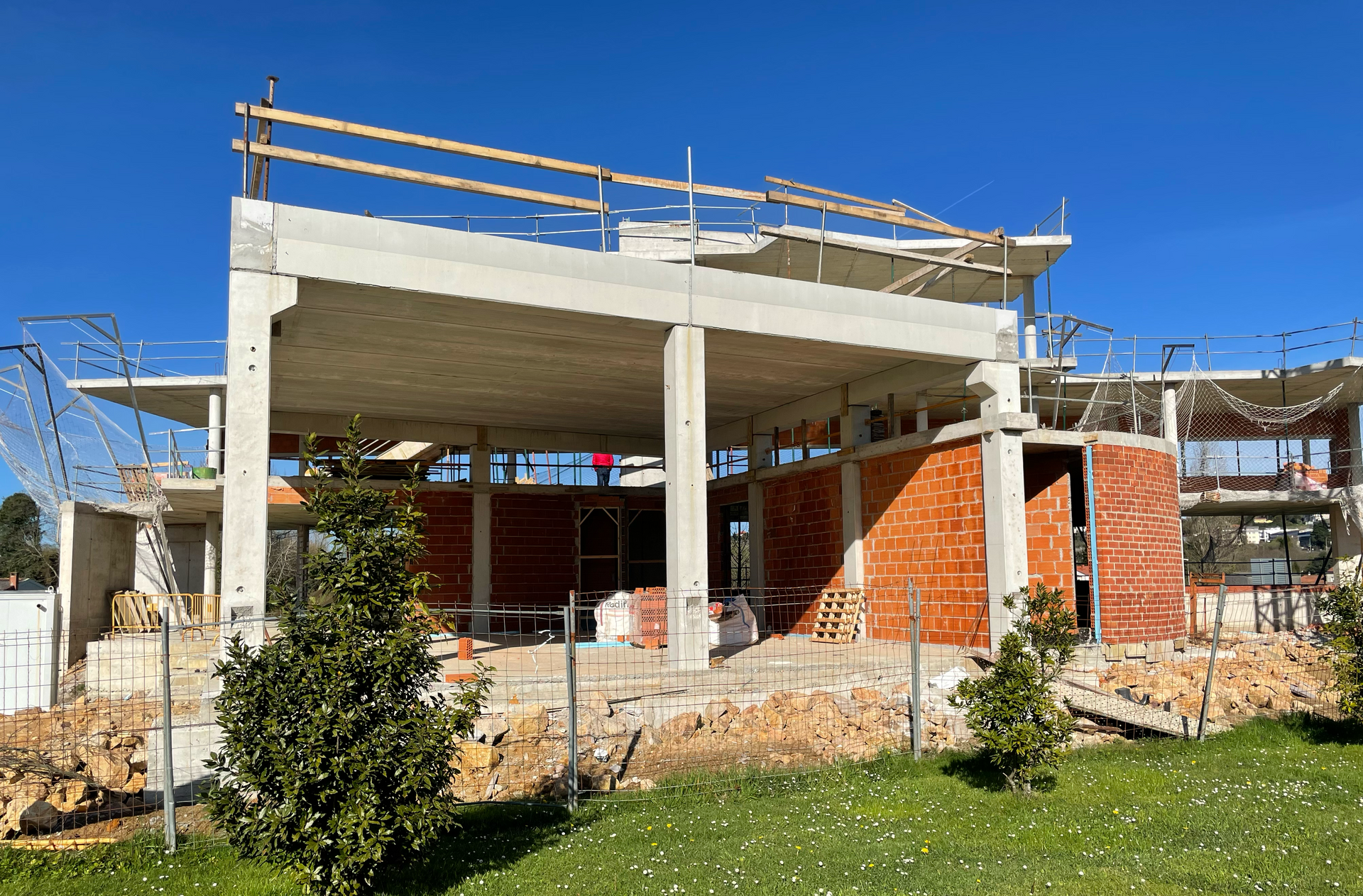 Se está construyendo un gran edificio en medio de un exuberante campo verde.