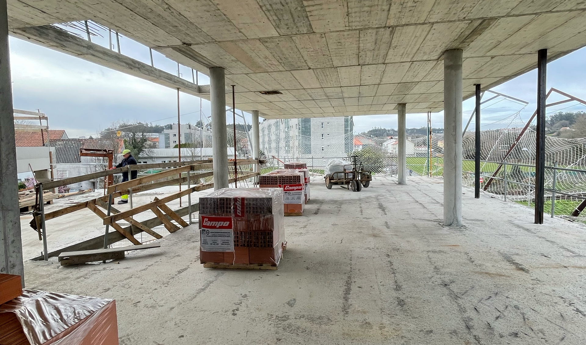 Un gran edificio en construcción con muchos ladrillos en el suelo.