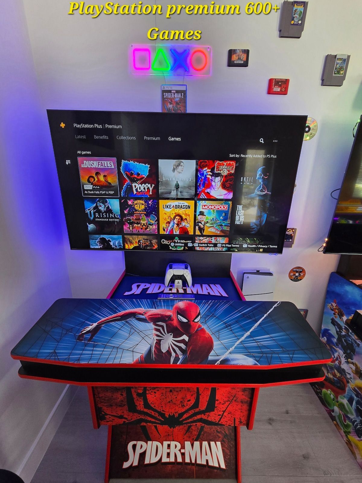 Spider-Man-themed gaming setup with TV, neon sign, and red-and-blue desk 