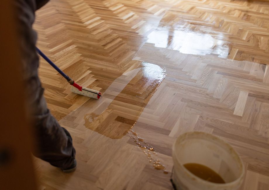 Une personne vitrifiant un parquet