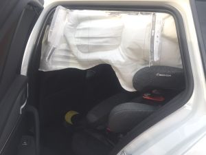 Seitenairbag, der sich auf dem Rücksitz eines Fahrzeugs entfaltet und die Sicherheitsfunktionen demonstriert.