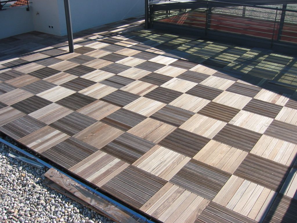 Terrasse extérieure avec un sol en carrelage à damier noir et blanc et une balustrade ombragée
