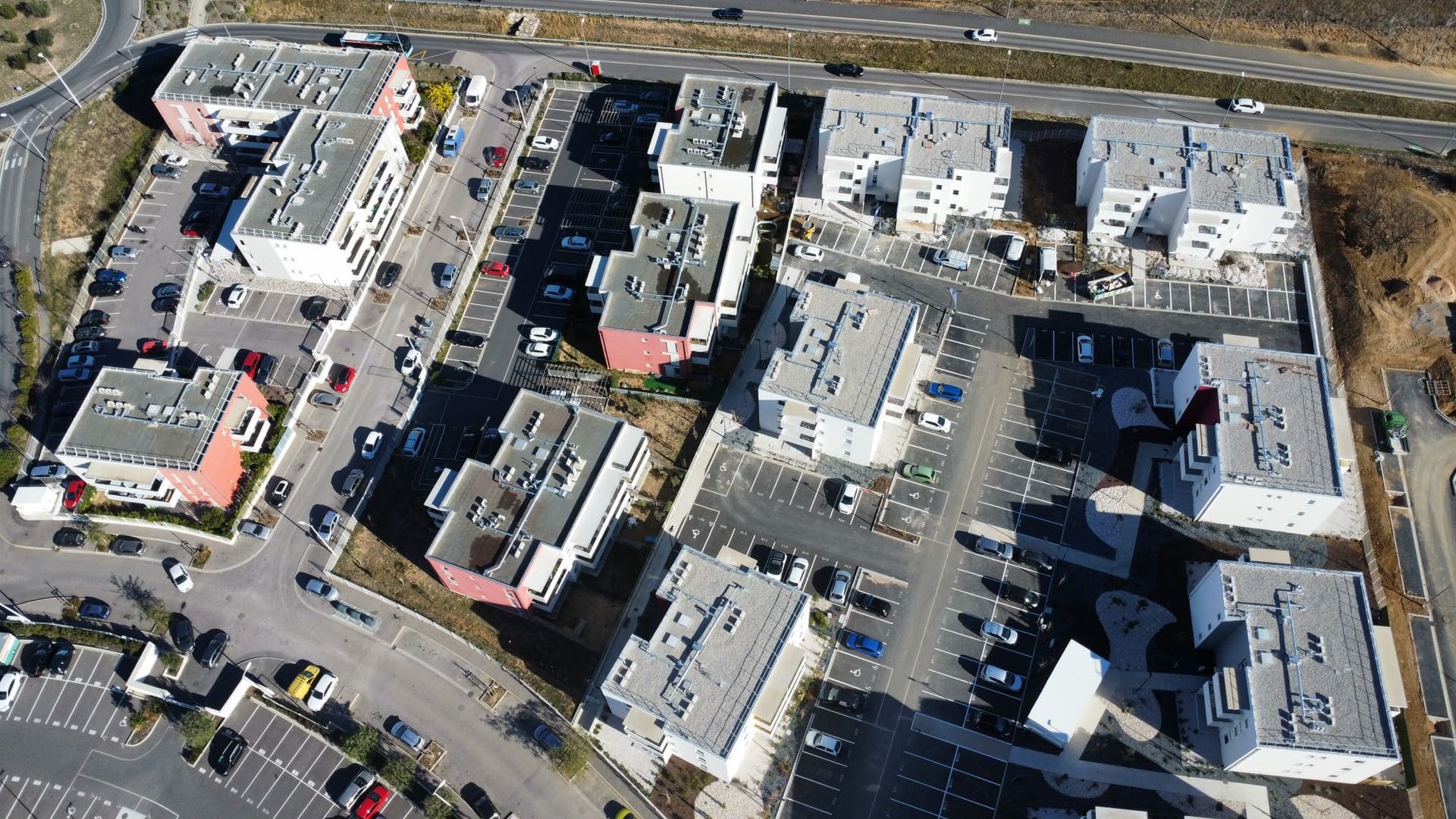 Vue aérienne d'un complexe commercial avec ses parkings, ses routes et les bâtiments environnants en hiver.
