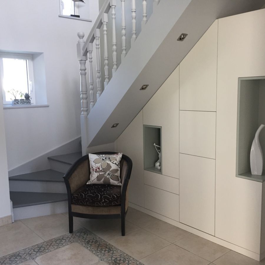 Entrée de maison avec un escalier et des placards de rangement