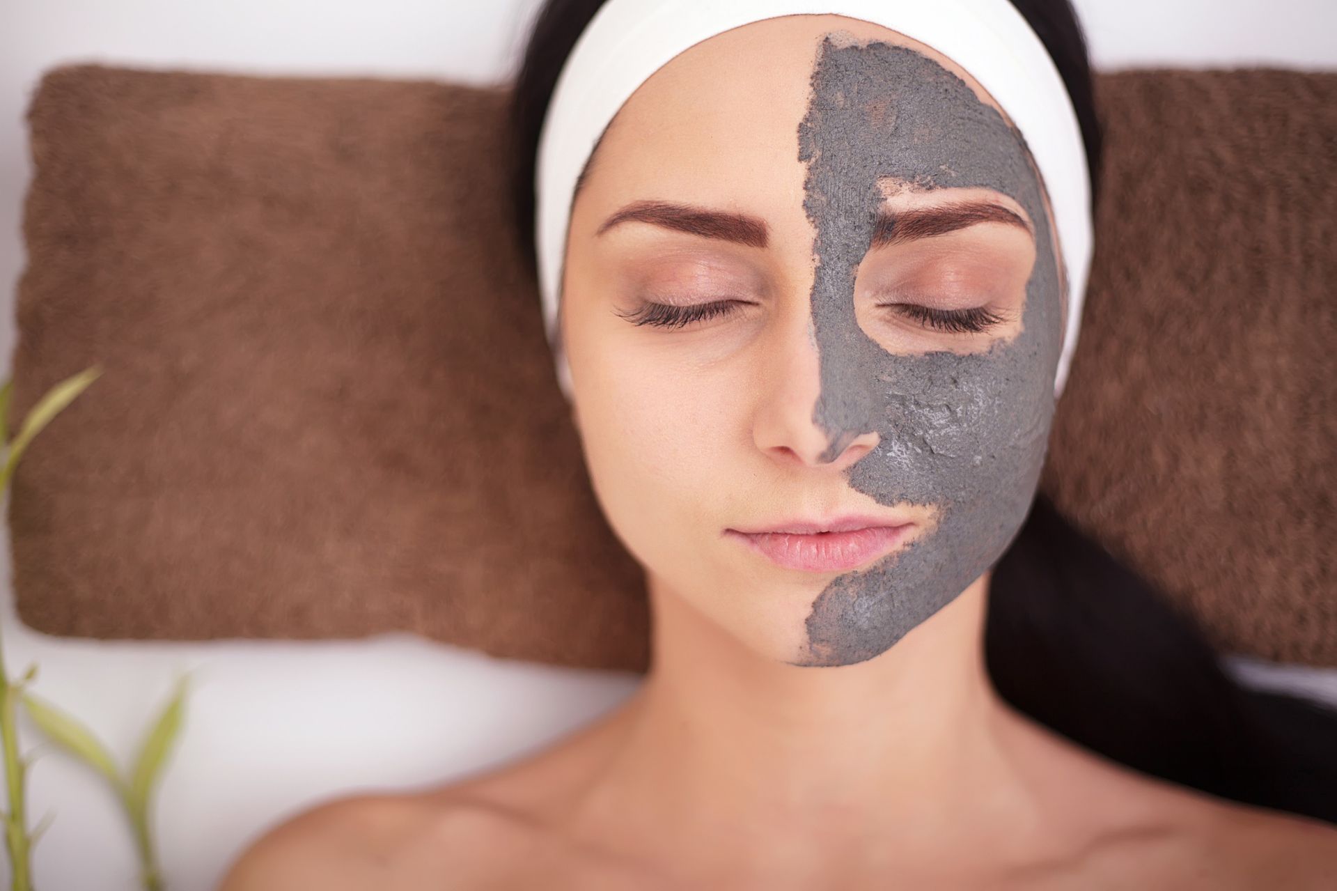 Una mujer está acostada con una máscara negra en su cara.