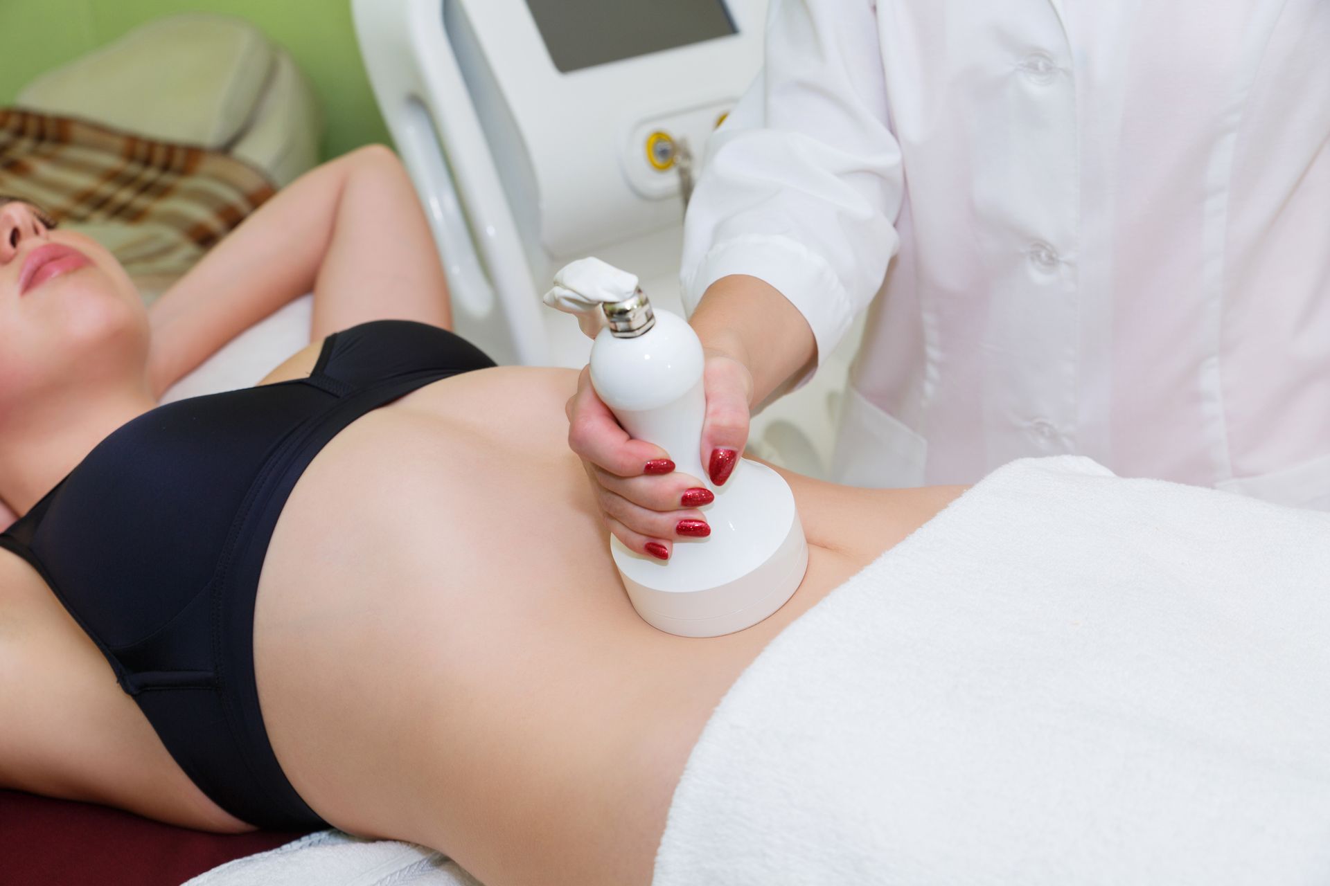 Una mujer está recibiendo un tratamiento de cavitación en su estómago.