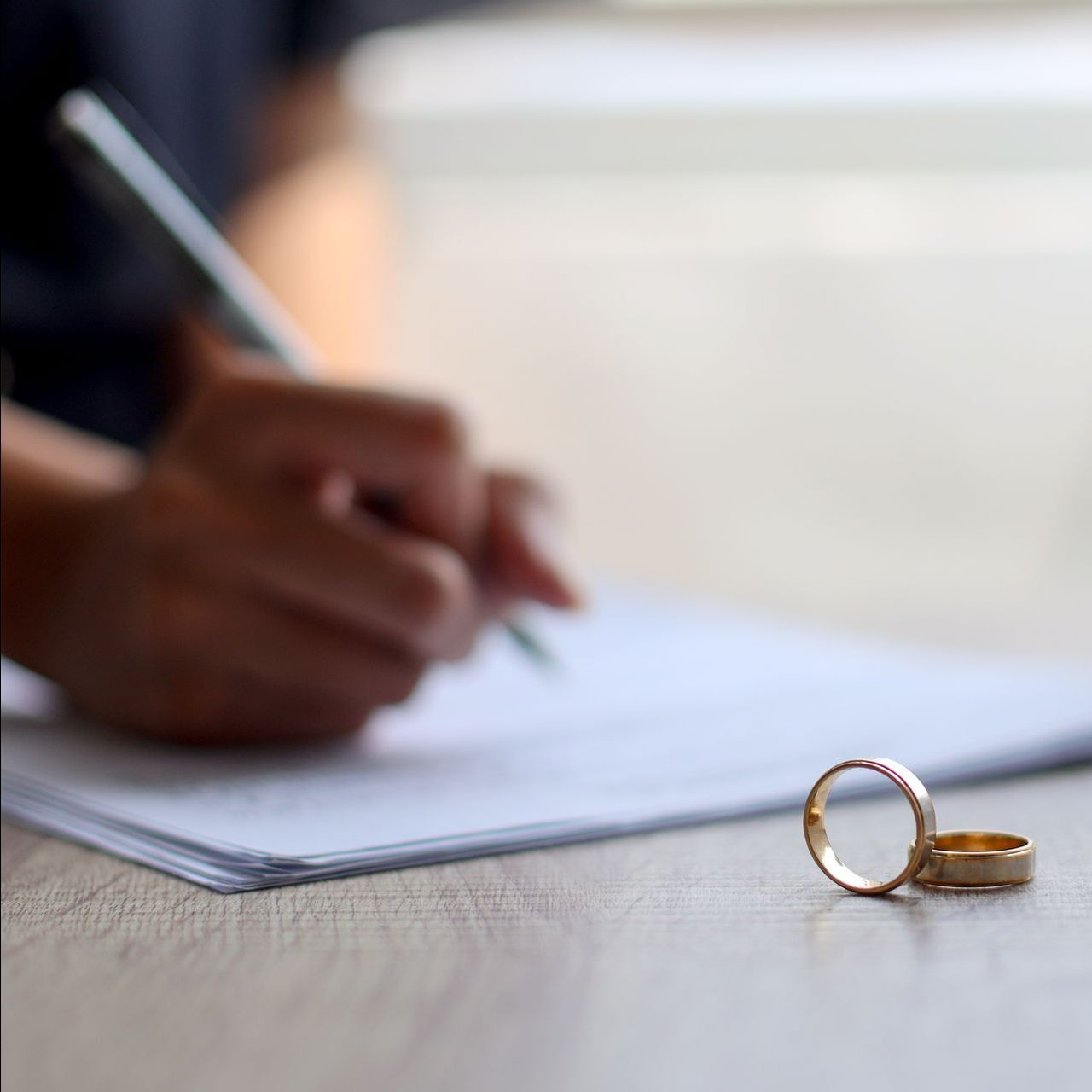 Bague, documents et personne en train d'écrire