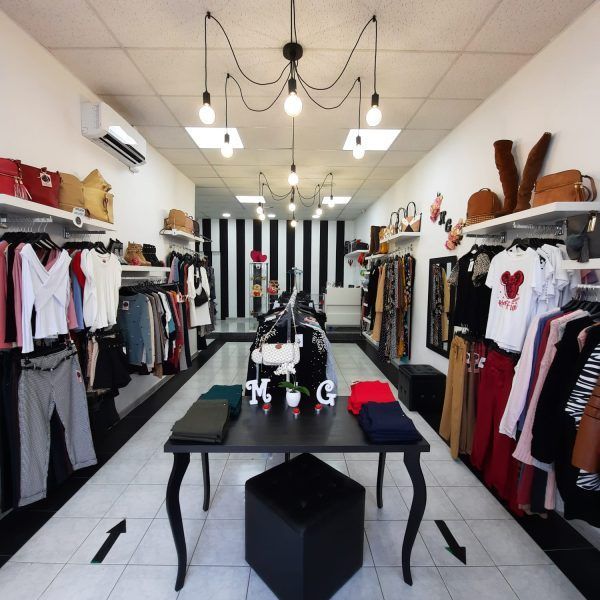 El interior de una tienda de ropa con una mesa en el medio.