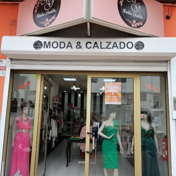 Un escaparate con un cartel que dice moda y calzado