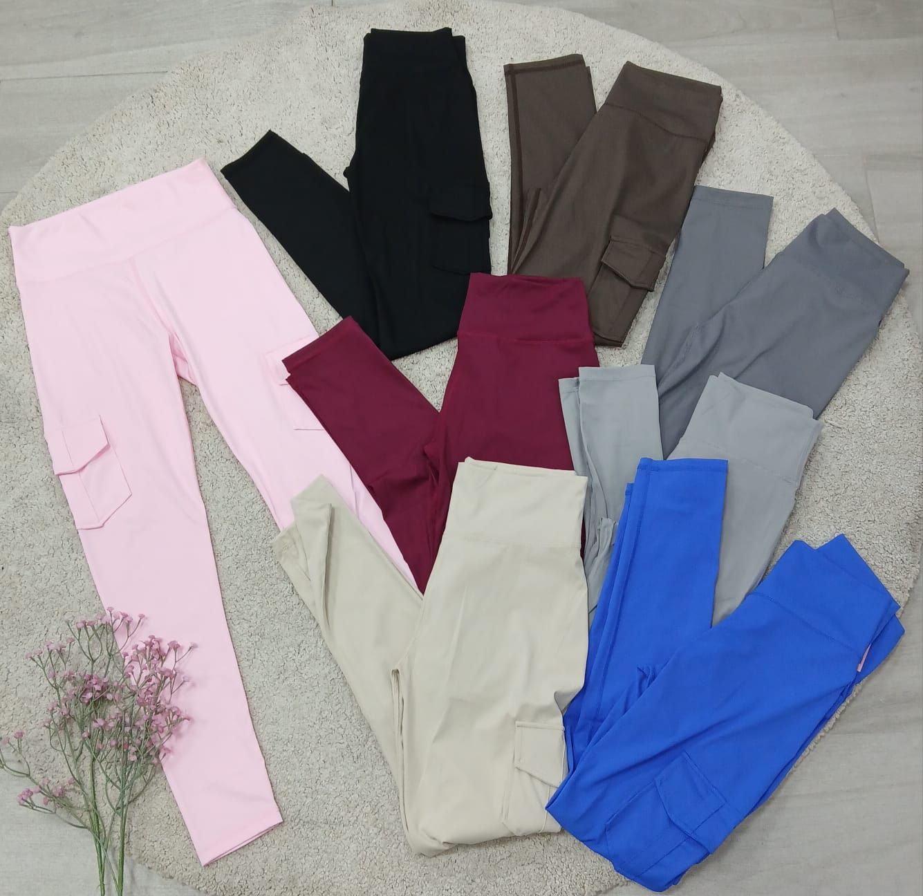 Un montón de pantalones de diferentes colores están sobre una alfombra.