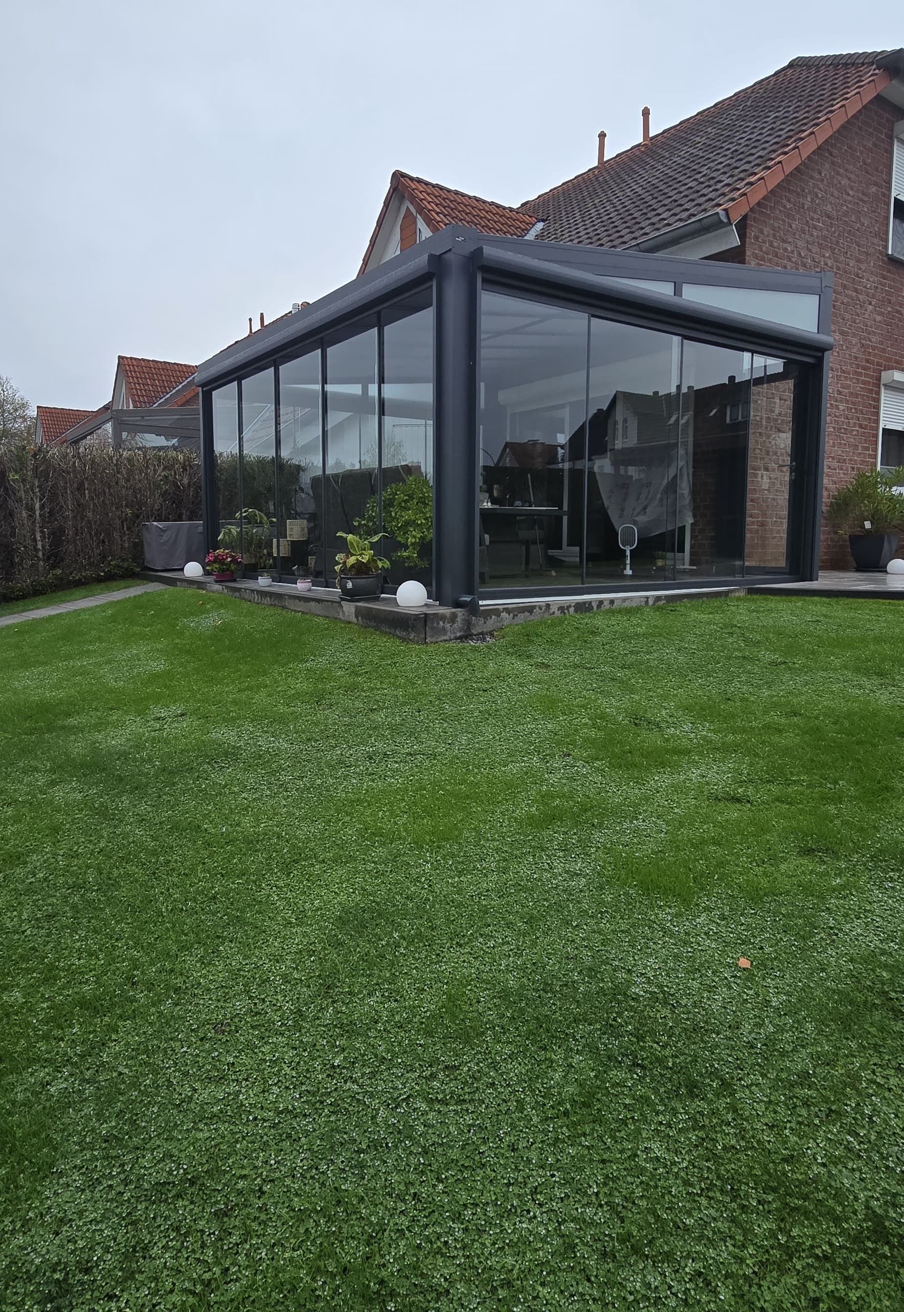 Ein Haus mit einer Glasterrasse davor.