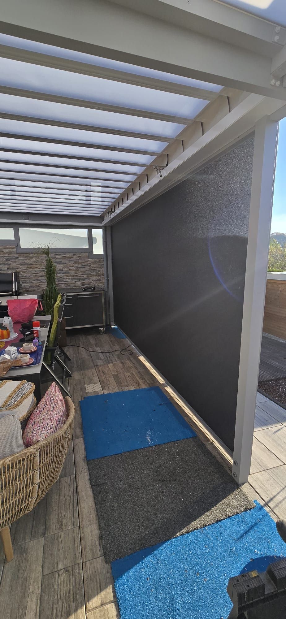 Eine Terrasse mit Tisch und Stühlen unter einer Pergola.