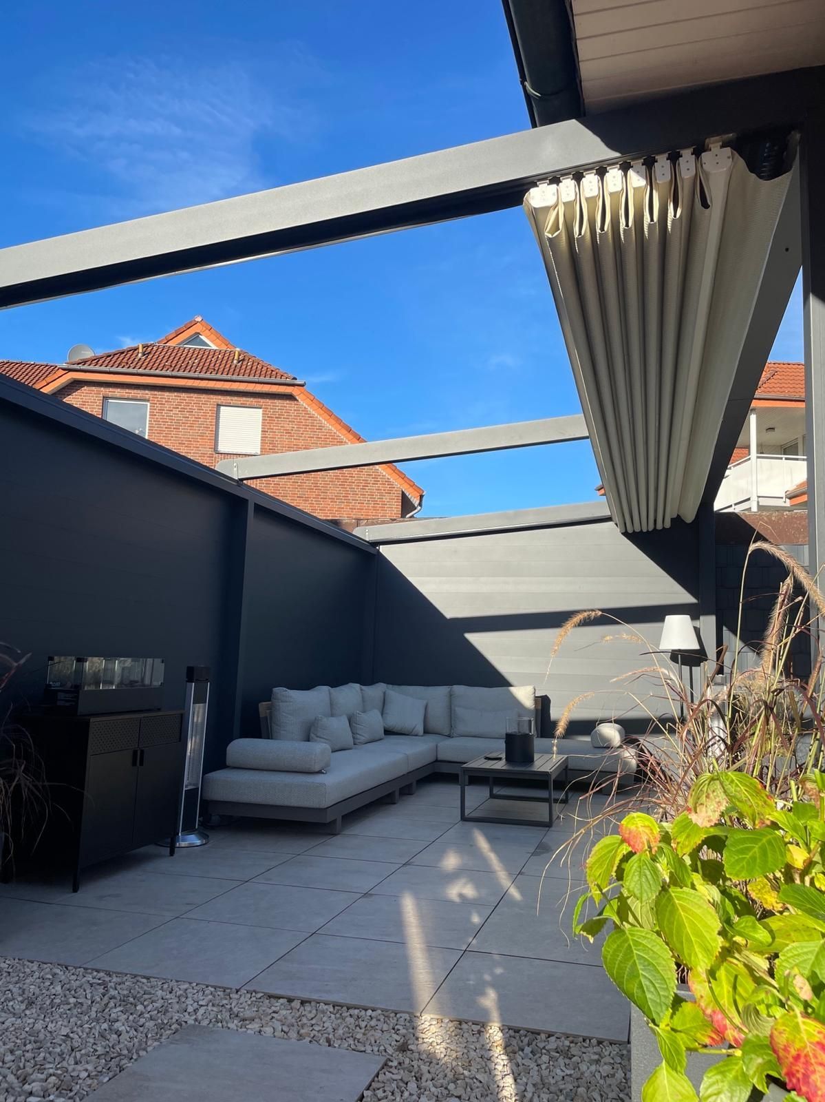 Außenterrasse mit Sitzbereich, Pergola und modernem Design.